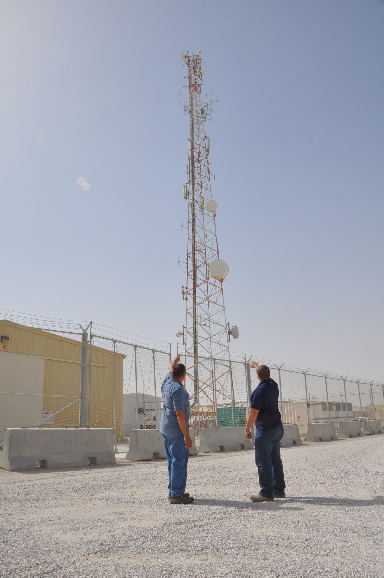Tony Bonilla and Chris Sykes, 379th Expeditionary Communication Squadron Cable TV technicians, observe the FM Radio tower antennas during a routine maintenance check on base.  (U.S. Air Force photo/Senior Airman Veronica McMahon)
