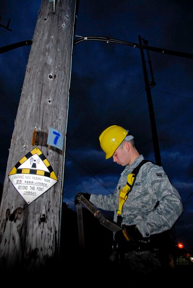 Airman 1st Class Brandon Courtain-Tharp, 18th Communications Squadron cable and antenna systems technician, inspects his safety gear before climbing an air-to-ground communications antenna pole for a semi-annual preventative maintenance inspection near Kadena’s flight line, March 8. The cable and antenna systems section is responsible for rerouting essential communication cables through each office and maintaining pre-existing lines on Kadena, whether they have to climb 90-foot poles, or drill through 18-inch-thick concrete walls. (U.S. Air Force photo/Airman 1st Class Maeson L. Elleman)