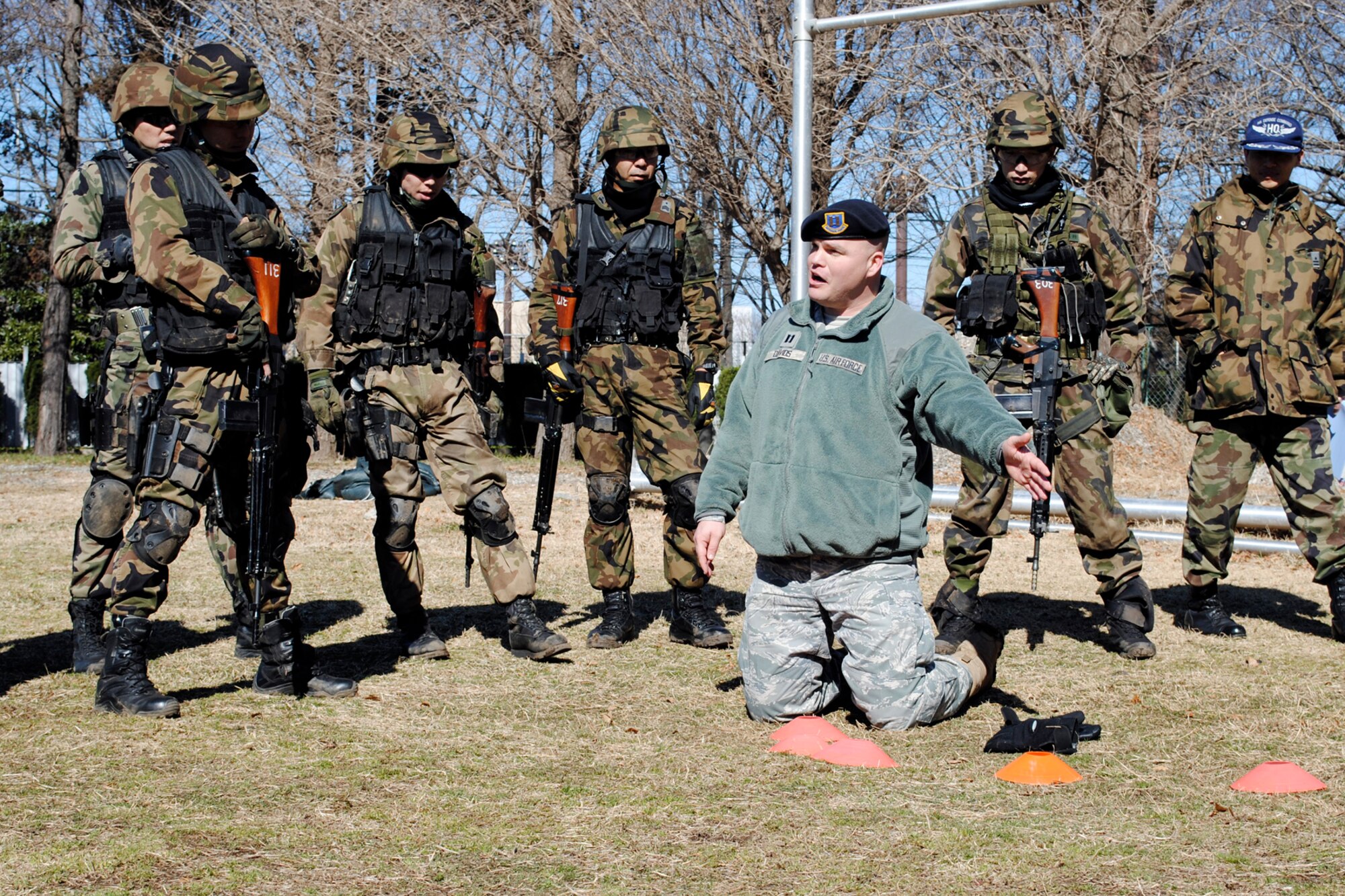 FUCHU AIR BASE, Japan -- Capt. John Davids, 5th Air Force A7S chief of operations and lead project officer for the training, instructs security guards from the Japan Air Self Defense Force on team movement tactics here Mar. 4. 5th Air Force and 374th Security Forces Squadron Airmen also trained the security guards on responding to near and far side ambush, building entry procedures, and challenging suspicious vehicles to help the security guards stand up their new Base Defense Development and Training Squadron, which will provide security guards throughout Japan with advanced security training for the first time. (U.S. Air Force photo/Capt. Will Powell)