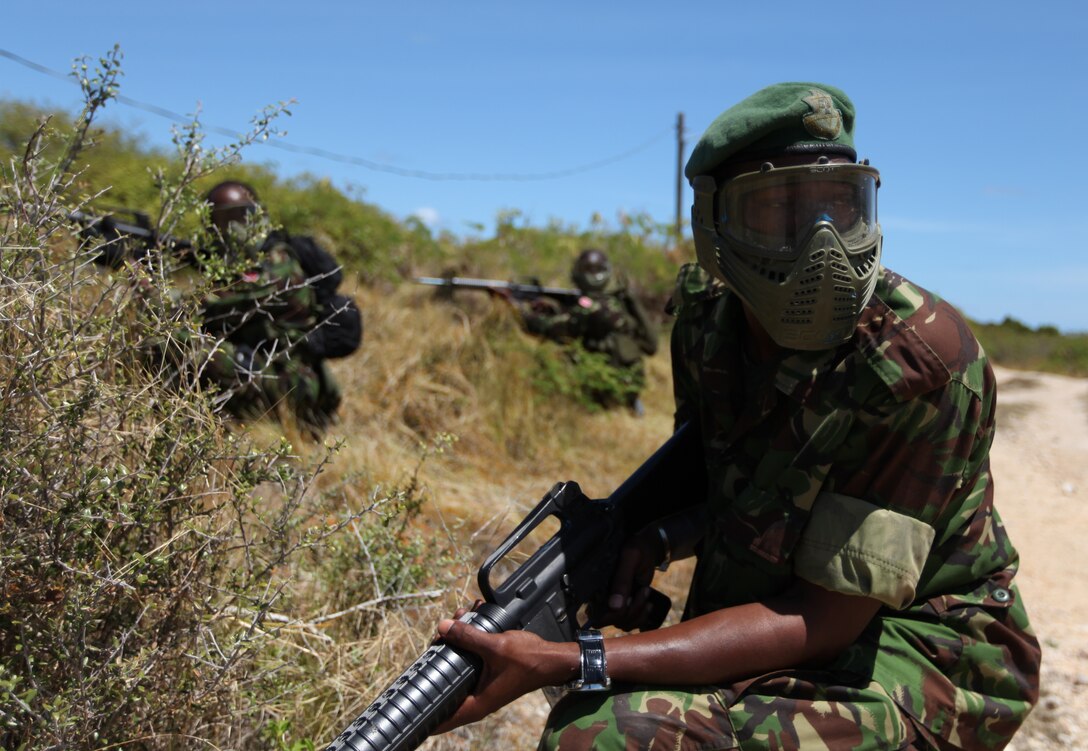 Soldiers from Trinidad and Tobago, take a knee and prepare to advance into combat town during close quarters battle training, March 8, as part of exercise Tradewinds 2011.::r::::n::