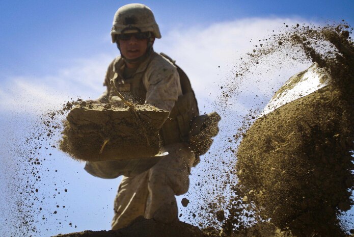 Lance Cpl. Marvin Lopez, 20, combat engineer, Engineer Company, Combat Logistics Battalion 3, 2nd Marine Logistics Group (Forward), shovels dirt during a bridge construction project in Haji Hanif Khan, Afghanistan, March 9. The combat engineers and heavy equipment operators of CLB-3's Engineer Company have conducted several civil development and military construction projects throughout Afghanistan since they arrived in October.