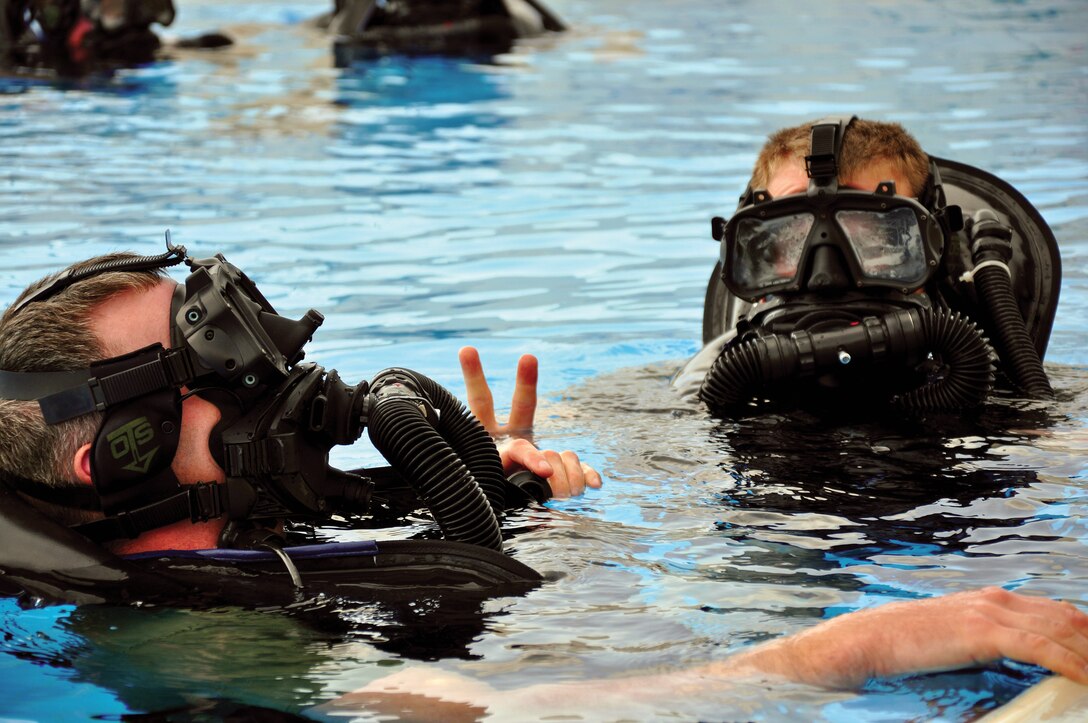 Combatant divers from 3d Reconnaisance Battalion, 3d Marine Division, III Marine Expeditionary Force dive in buddy teams in order to test the new Combat Diver Full Face mask at the Camp Schwab Aquatic Center here Mar. 9.