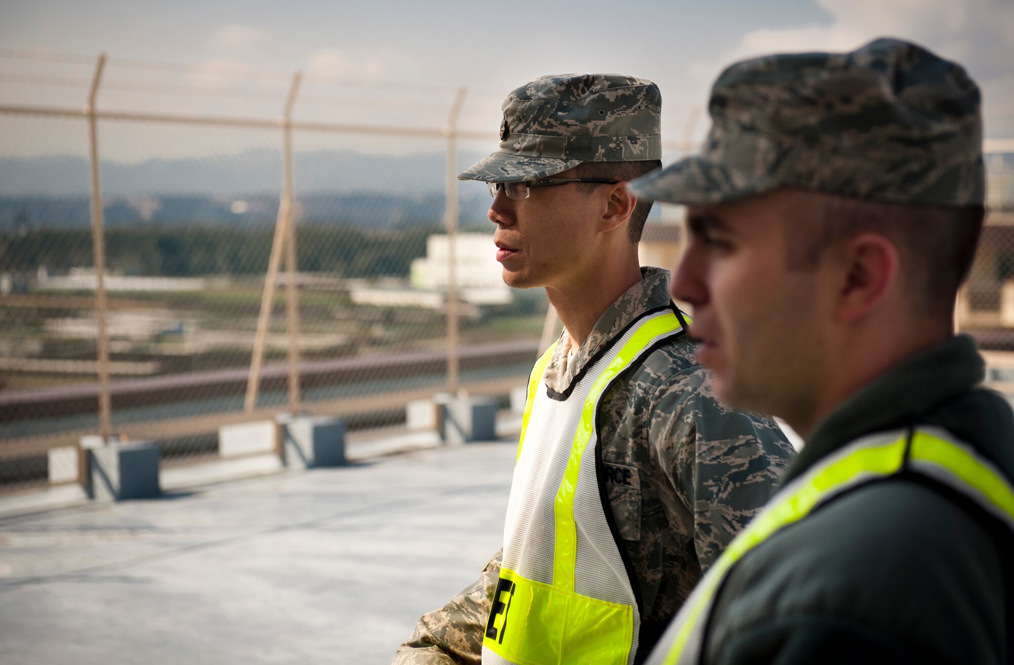 YOKOTA AIR BASE, Japan -- Maj. Anthony Ty, 374th Aerospace Medicine Squadron exercise evaluation team member, and Tech. Sgt. Travis Kelsey, 35th Civil Engineer Squadron EET member, watch personnel from their squadrons identify a simulated suspicious substance at a residential tower during an Operational Readiness Exercise here March 9. The EET provides feedback and identifies areas for improvement for the 374th Airlift Wing while strengthening mission readiness and capability. (U.S. Air Force photo/Staff Sgt. Samuel Morse)