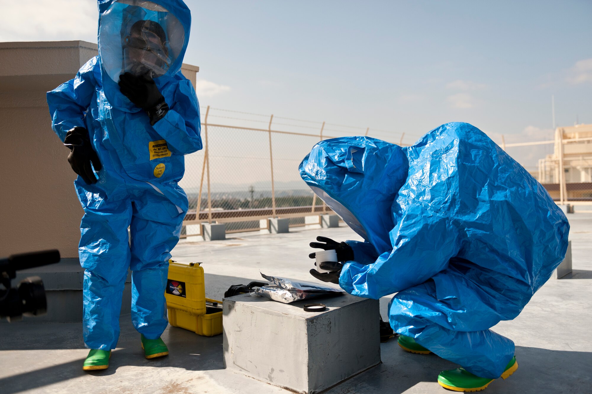 YOKOTA AIR BASE, Japan -- Senior Airman Richard Riley (left), 374th Aerospace Medicine Squadron bio-environmental engineering technician, and Senior Airman Travis McCallum, 374th Civil Engineer Squadron emergency management technician, prepare to identify a simulated suspicious substance found at a residential tower during an Operational Readiness Exercise here March 9. The team was called in after Airmen from the 374th Security Forces Squadron discovered a white powder scattered from a can on the roof. (U.S. Air Force photo/Staff Sgt. Samuel Morse)