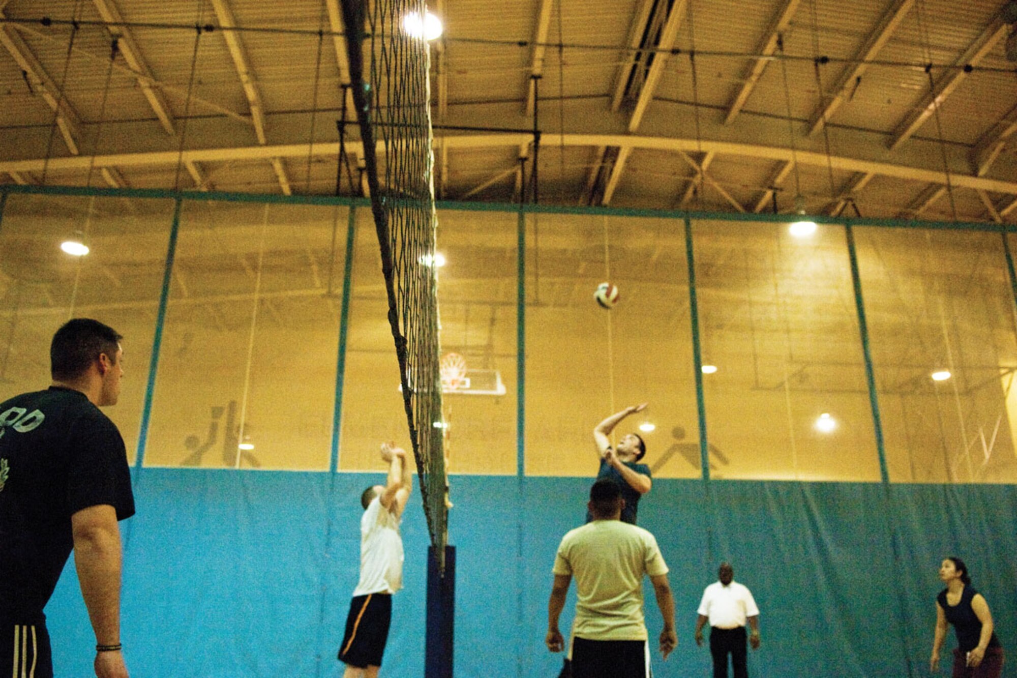 Members of the 673d Civil Engineer Squadron’s intramural volleyball team (left) prepare to defend a spike during a game against the 673d Contracting Squadron team. The teams played two matches. The 673d CES won both matches, 25-20 in the first and 25-21 in the second. (U.S. Air Force photo/Airman 1st Class Jack Sanders)