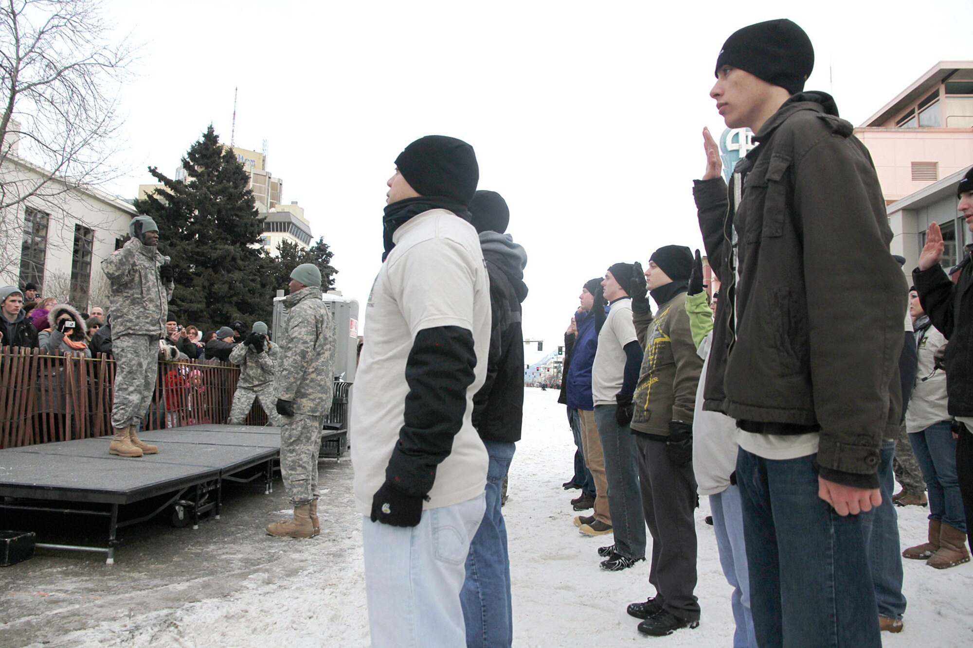 Col. Barry K. Williams, commander of the 3rd Maneuver Enhancement Brigade, enlists 20 new Soldiers and reenlists 10 Soldiers March 5 during the Fur Rendezvous festival in downtown Anchorage. (U.S. Army Staff Sgt. Jason Epperson)