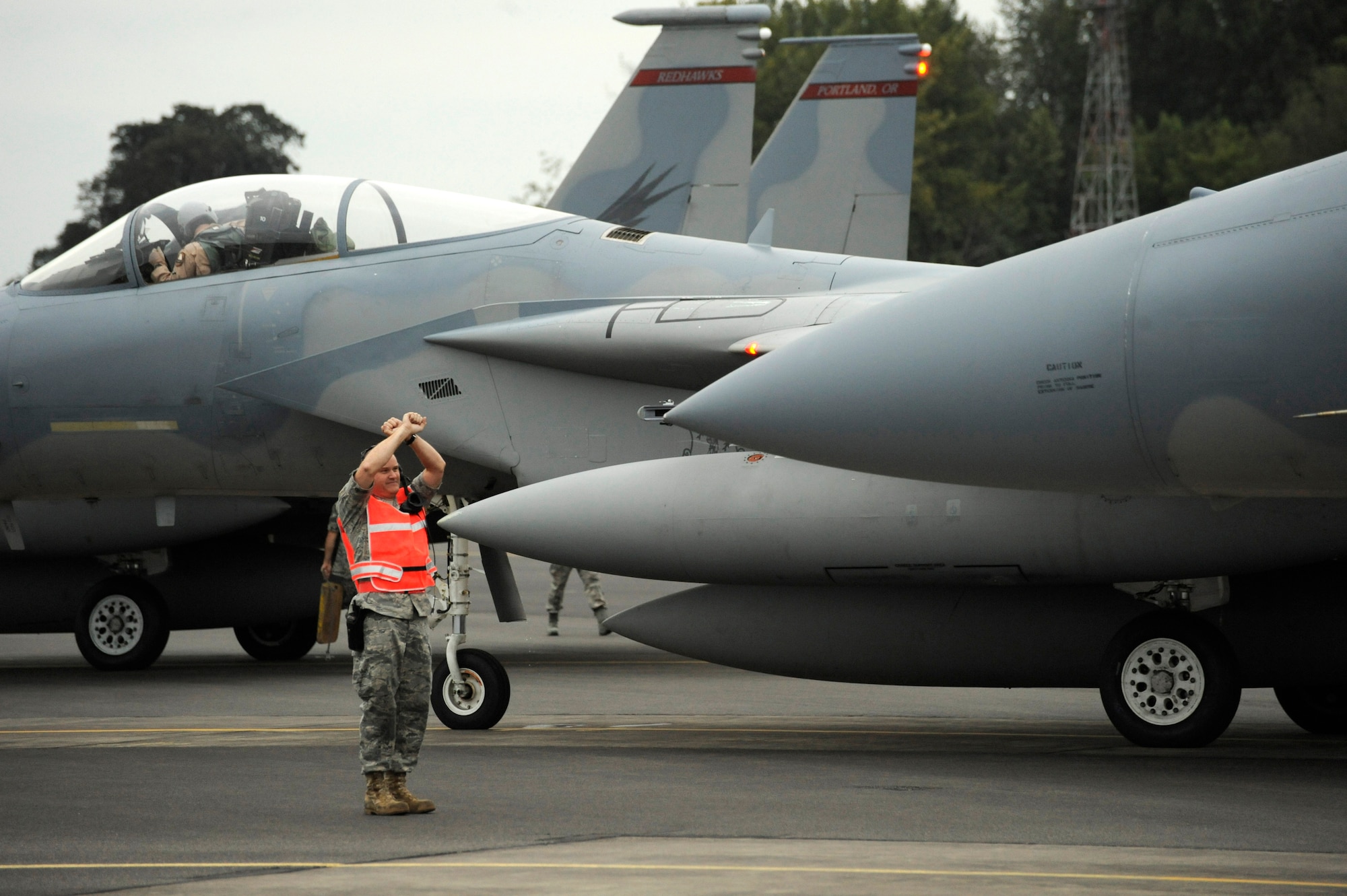 An Oregon National Guard Airman from the 142nd Fighter Wing marshals several F-15C Eagles at the Portland Air National Guard Base, Portland, Ore., on October 2nd, 2010. (U.S. Air Force photograph by Staff Sgt. John Hughel, 142nd Fighter Wing Public Affairs)