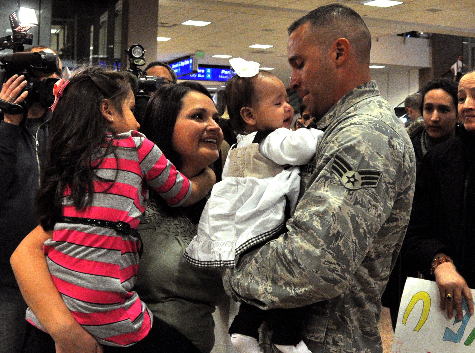 Senior Airman Geiber Rea, 419th Civil Engineer Squadron, holds 5-month-old baby, Amelie, for the first time as wife, Cecilia, and daughter, Heather, look on. Airman Rea watched Amelie’s birth via Skype while deployed to Bagram Airfield, Afghanistan. (U.S. Air Force photo/Airman Crystal Charriere)
