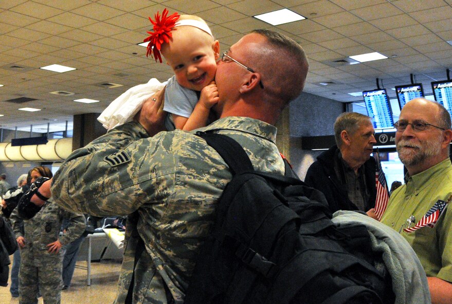 Staff Sgt. Galen Schatzman, 419th Civil Engineer Squadron, kisses his daughter upon returning from a six-month deployment to Bagram Airfield, Afghanistan. Sergeant Schatzman and about 30 Air Force Reservists from the 419th CES came home to cheers and applause March 9. (U.S. Air Force photo/Airman Crystal Charriere)