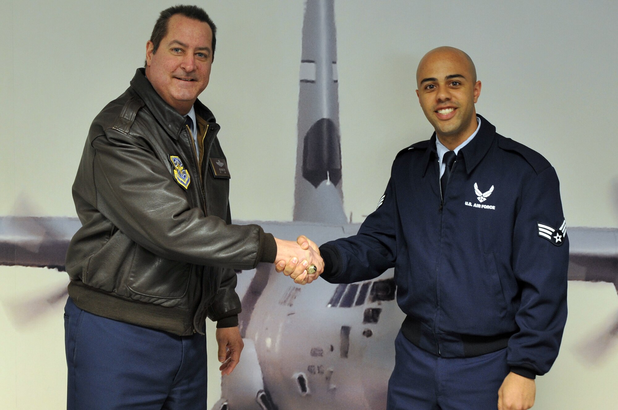 Col. Ken Walters (left), acting 19th Airlift Wing vice commander, presents a coin March 7, 2011, to Senior Airman Kyle Jefferson, a 41st Airlift Squadron instructor loadmaster, at Little Rock Air Force Base, Ark. Airman Jefferson was instrumental in the unit response to the recent snow storm. (U.S. Air Force photo by Airman 1st Rusty Frank)