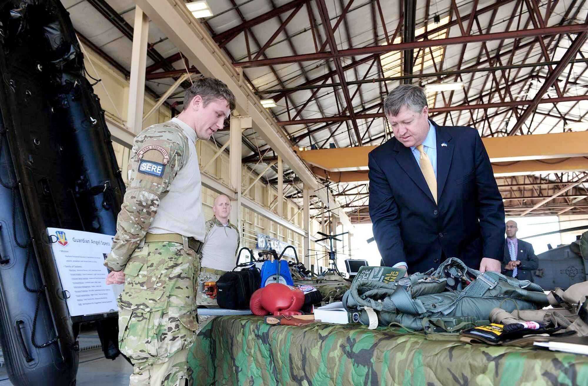 Secretary of the Air Force Michael Donley and Senior Airman Joe Dittmer discuss the equipment used for survival, evasion, resistance and escape training March 8, 2011, during the secretary's visit to Moody Air Force Base, Ga. Airman Dittmer is a SERE specialist assigned to the 347th Operation Support Squadron. (U.S. Air Force photo/Senior Airman Stephanie Mancha)
