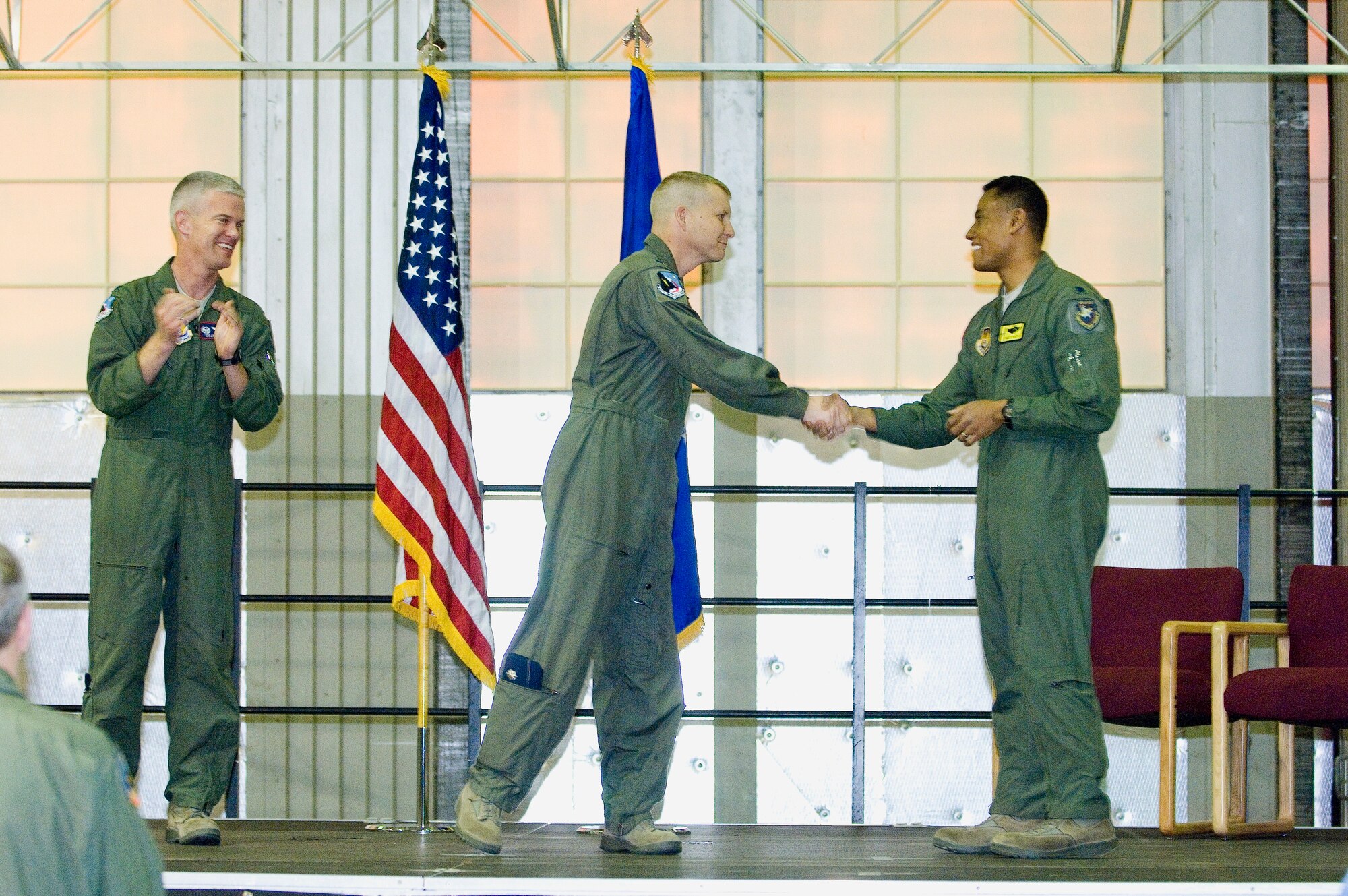 New Global Vigilance Combined Test Force director, Lt. Col. Landon L. Henderson (center) shakes the hand of outgoing director, Lt. Col. Nathan Smith, during a change of directorship ceremony Mar. 4. Col. Colin Miller, 412th Operations Group commander (far left) presided over the ceremony. The GVCTF oversees all unmanned aerial vehicle testing for the 412th Test Wing. (Air Force photo by Rob Densmore)