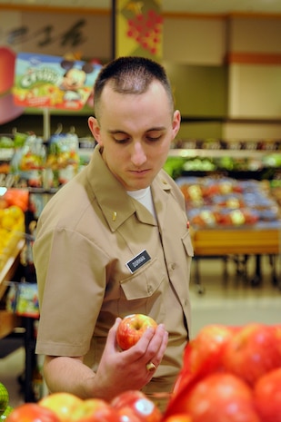 Ens. James Dorman, a student at Navy Nuclear Power Training Command, chooses an apple in the fresh produce section of Joint Base Charleston – Weapons Station Commissary during his lunch hour, March 2.  