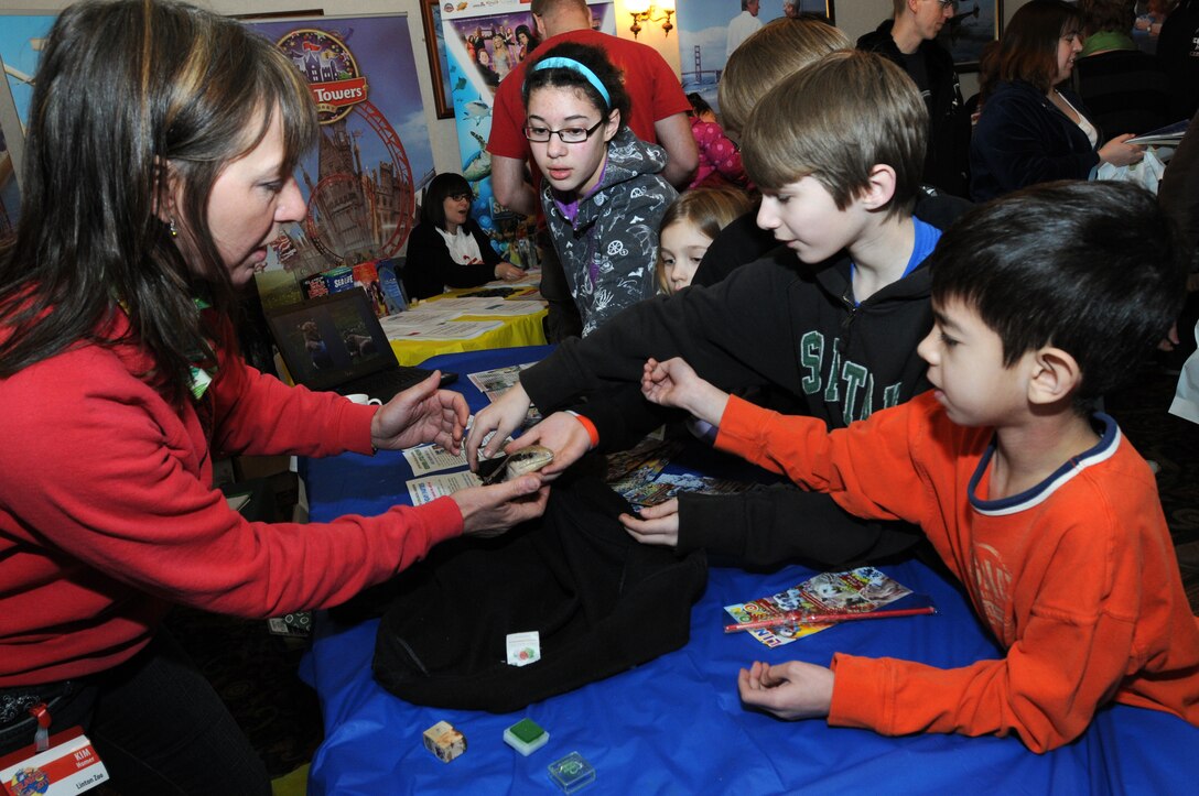 ROYAL AIR FORCE LAKENHEATH, England – Kim Simmons, Linton Zoo manager, shows Dot, a blue-tongue skink, to children at the 2011 Travel Fair here March 5. More than 2,000 people from RAFs Lakenheath, Mildenhall and Feltwell attended the fair, which featured 64 vendors offering a variety of travel opportunities. The travel fair was put on by the RAF Lakenheath Information, Tickets and Travel office. (U.S. Air Force photo/Staff Sgt. Stephen Linch)