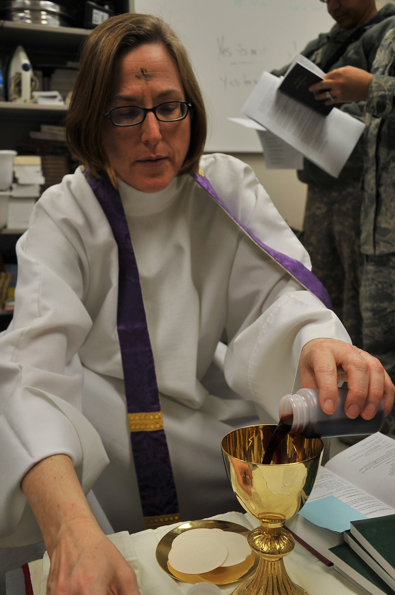 Chaplain (Maj.) Sarah Shirley prepares wine as a part of Holy Communion during an
Ash Wednesday service at Craig Joint Theater Hospital, Bagram Airfield,
Afghanistan, 9 March 2011. (U.S. Air Force photo by Staff Sgt. Larry Moore)
