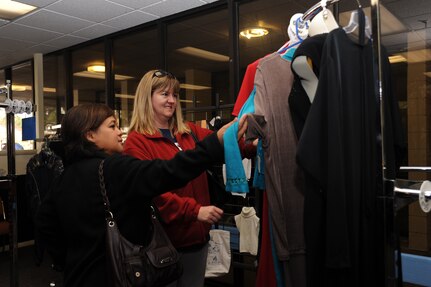 Maureen Robinson (left), wife of the 437th vice wing commander Col. Brian Robinson,
and Cari Whitehill, wife of currently deployed 628th Comptroller Squadron commander Lt. Col. Trevor Whitehill, look at a dress during a leadership spouse preview of the on-base consignment shop March 7, at it’s new location. The consignment shop will re-open March 8 and is now located next to the Air Base Youth Center. (U.S. Air Force photo/ Airman 1st Class Jared Trimarchi)
