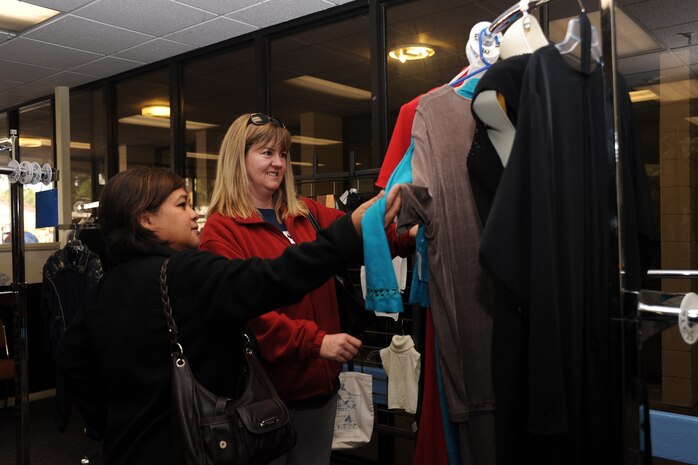 Maureen Robinson (left), wife of the 437th vice wing commander Col. Brian Robinson,
and Cari Whitehill, wife of currently deployed 628th Comptroller Squadron commander Lt. Col. Trevor Whitehill, look at a dress during a leadership spouse preview of the on-base consignment shop March 7, at it’s new location. The consignment shop will re-open March 8 and is now located next to the Air Base Youth Center. (U.S. Air Force photo/ Airman 1st Class Jared Trimarchi)
