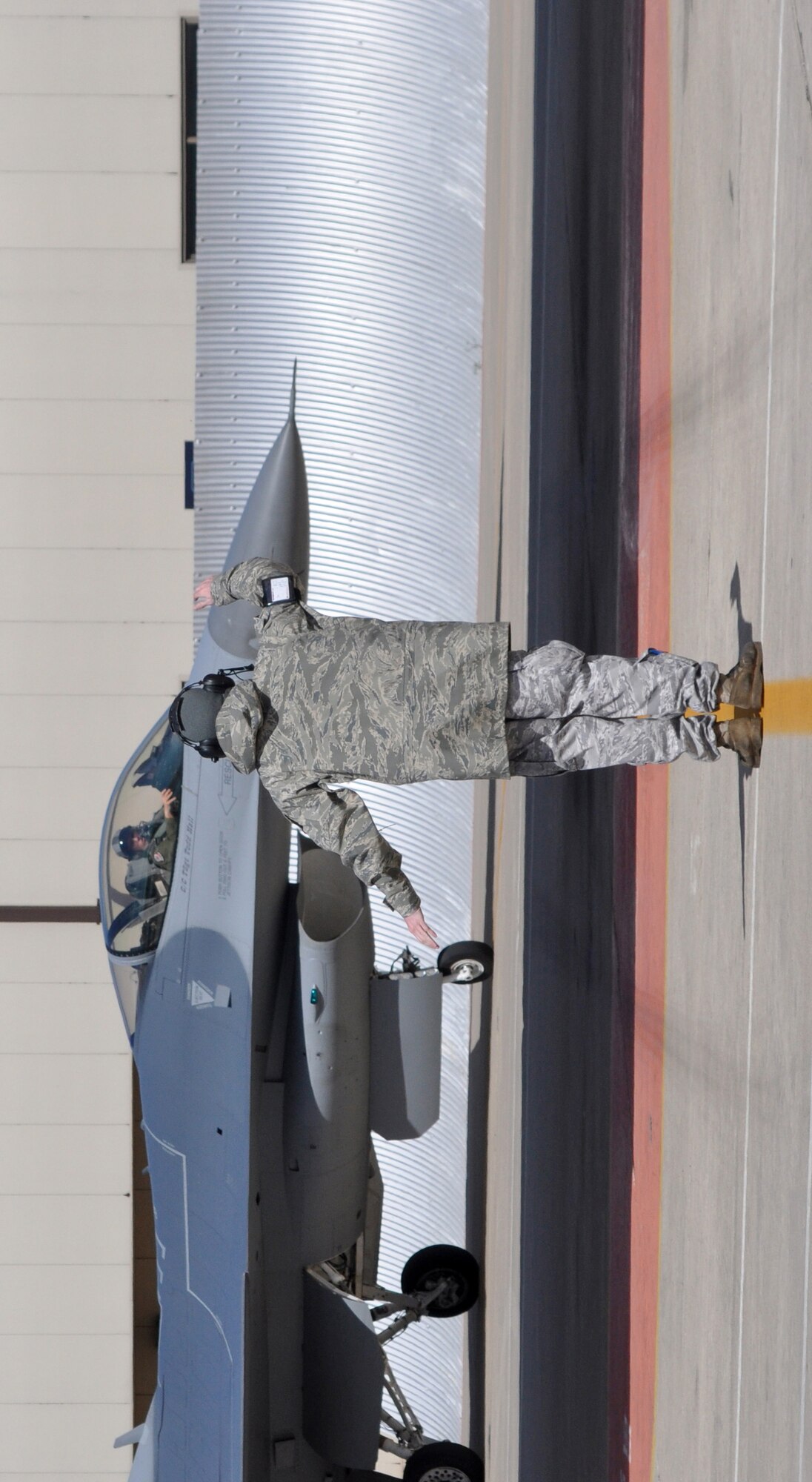 Staff Sgt. Taylor Myers signals directions to a 457th Fighter Squadron F-16C pilot in order to marshall the aircraft to its parking spot at Naval Air Station Fort Worth Joint Reserve Base, Texas, March 5, during a "surge" exercise.  Sergeant Myers, a crew chief in the 301st Maintenance Squadron, had approximately two hours to get the aircraft ready for its next sortie.  The 301st Fighter Wing, an Air Force Reserve Command unit, held the exercise to prepare for its upcoming operational readiness inspection.  The 301st Maintenance Group produced 38 sorties for the 457th FS pilots to fly in one day.(U.S. Air Force photo/Lt Col David Kurle)