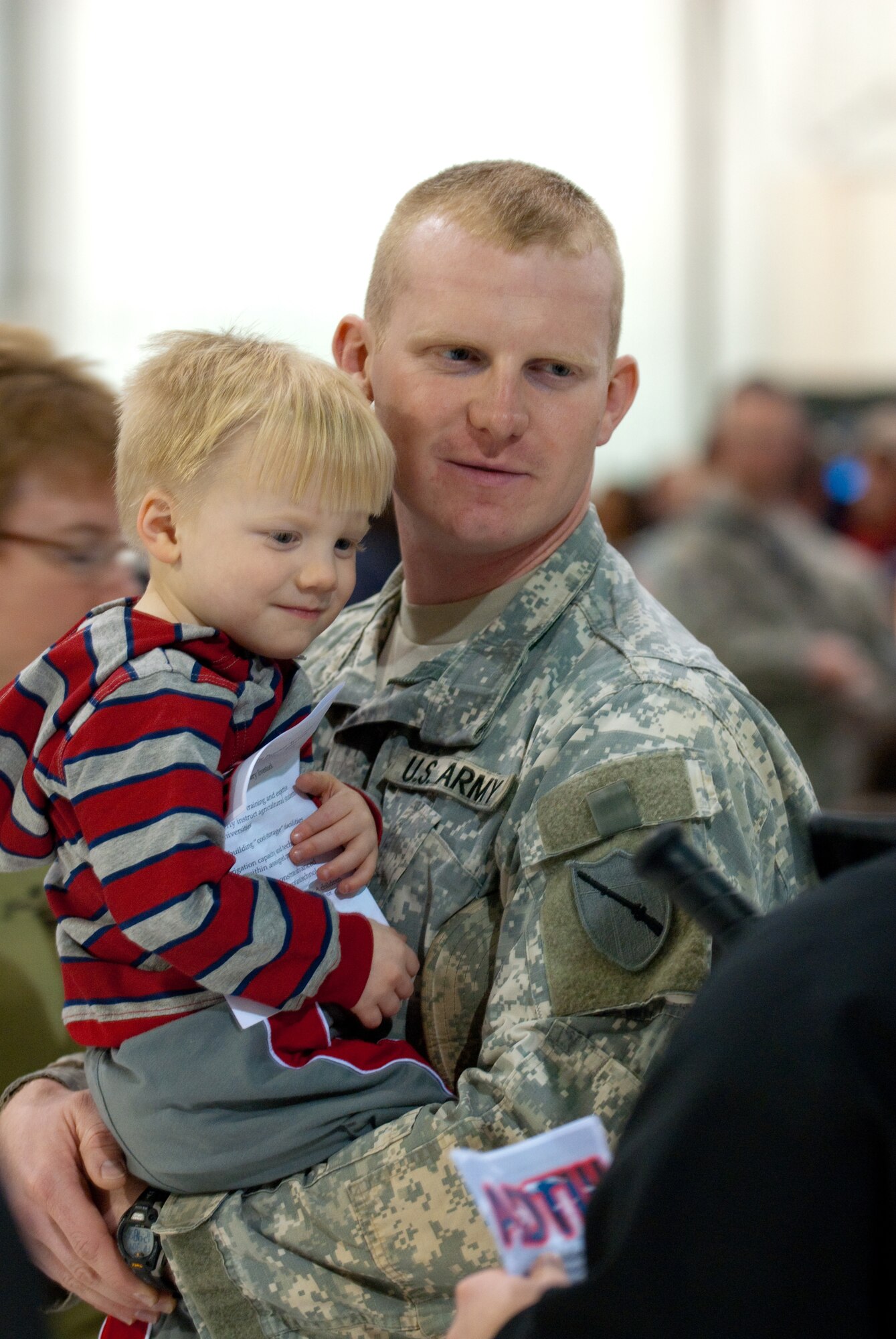 Army Sgt. Joshua Martin of Murray, Ky., a security force team leader for the Kentucky National Guard's Agribusiness Development Team III, holds his 3-year-old son, Gabriel, prior to the team's farewell ceremony March 4, 2011, at the Kentucky Air National Guard Base in Louisville, Ky. Team members are deploying to Afghanistan, where they will help Afghan farmers become agriculturally self-sufficient.  (U.S. Army photo by Staff Sgt. Aaron Hiler, 133rd Mobile Public Affairs Detachment)