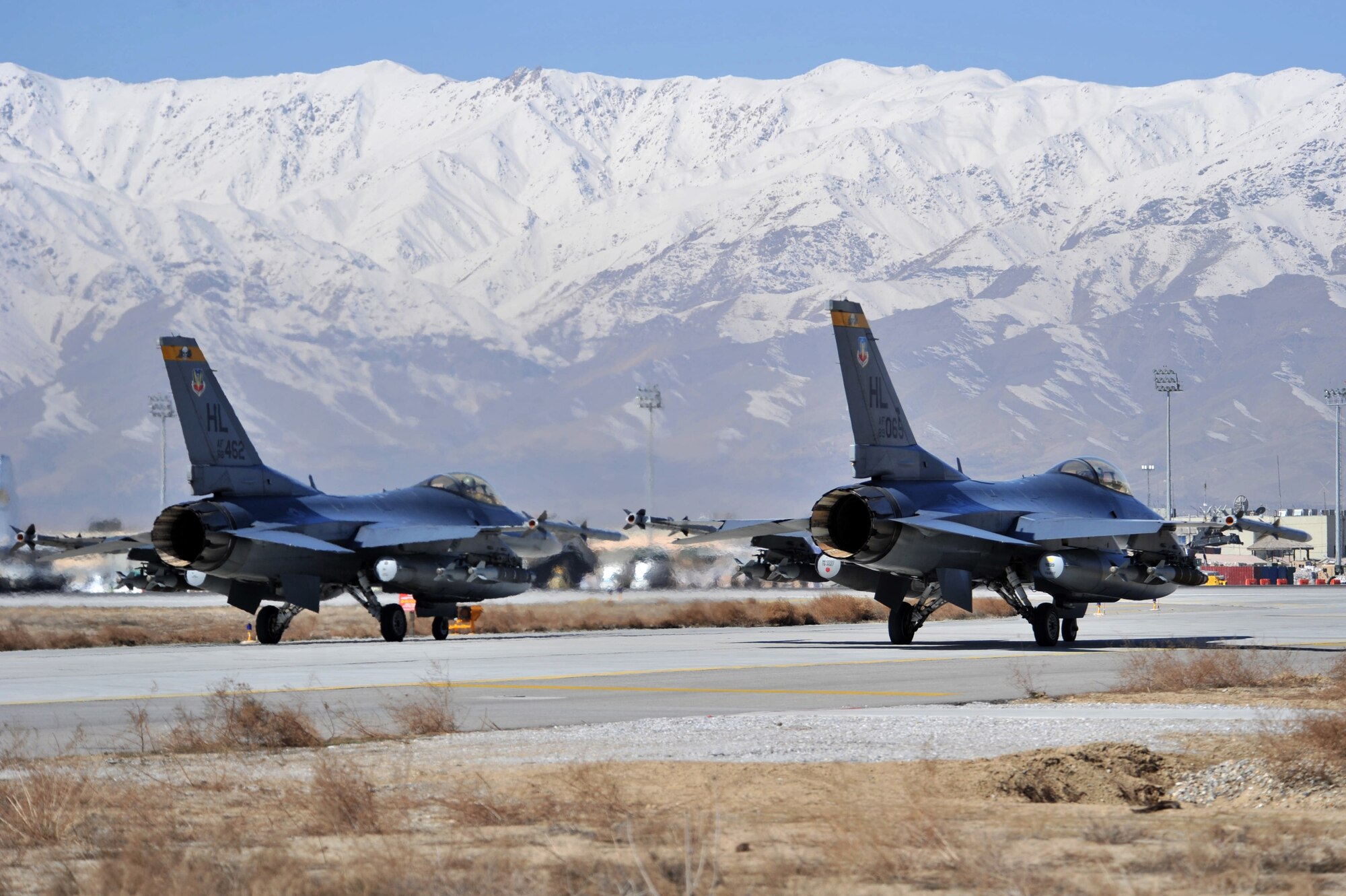 Two F-16 Fighting Falcons wait as they prepare to taxi toward the end of the runway at Bagram Airfield, Afghanistan, March 9, 2011 in support of Operation Enduring Freedom. The jets belong to the 4th Expeditionary Fighting Squadron part of the 455th Air Expeditionary Wing. (U.S. Air Force photo by Senior Airman Sheila deVera)
