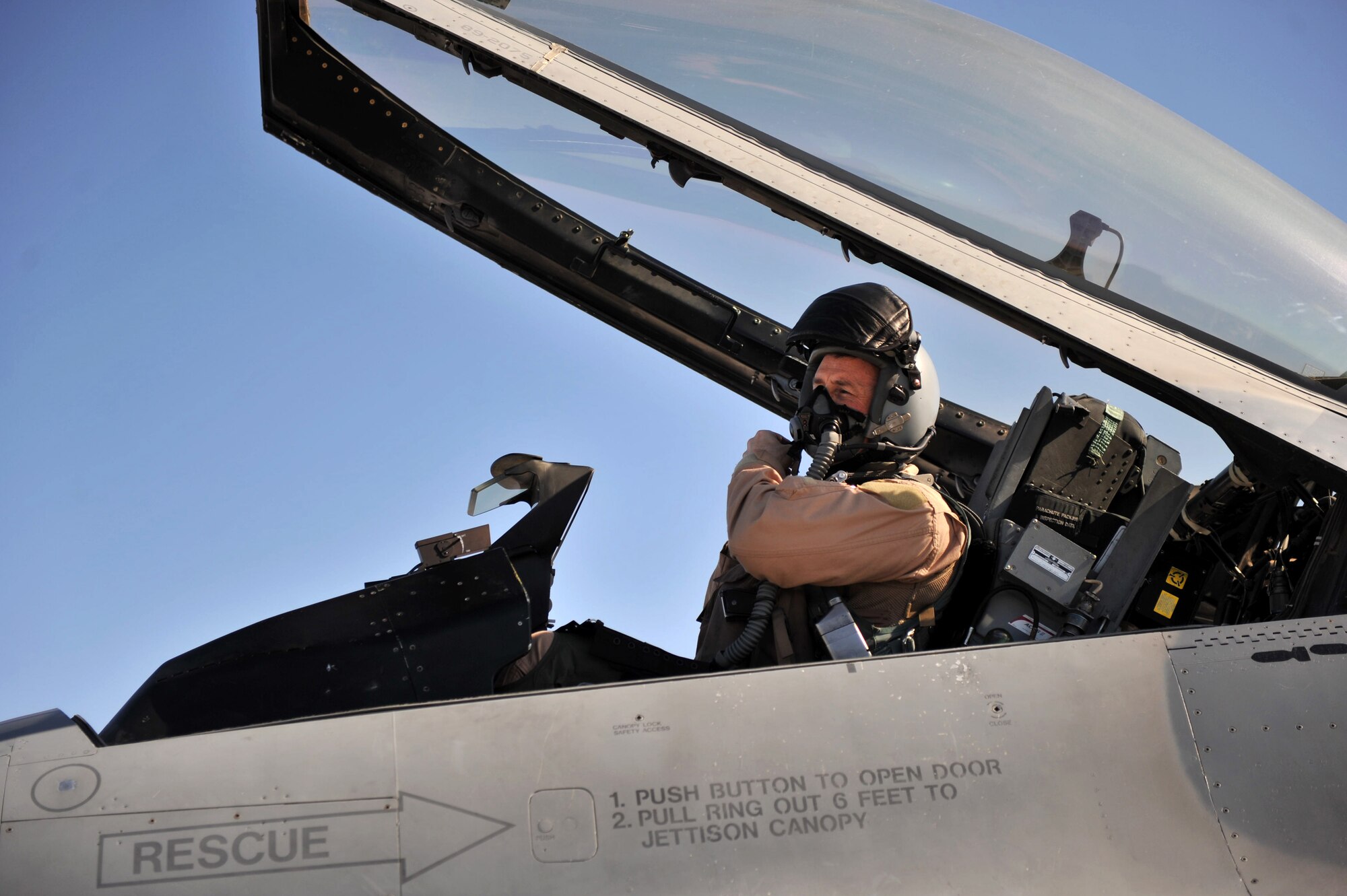 Lt. Col. Gerald Brown, 4th Expeditionary Fighter Squadron, dons his helmet before taking off in an F-16 Fighting Falcon at Bagram Airfield, Afghanistan, March 9, 2011. The 4th EFS launch F-16s around the clock in support of Operation Enduring Freedom. (U.S. Air Force photo by Senior Airman Sheila deVera)