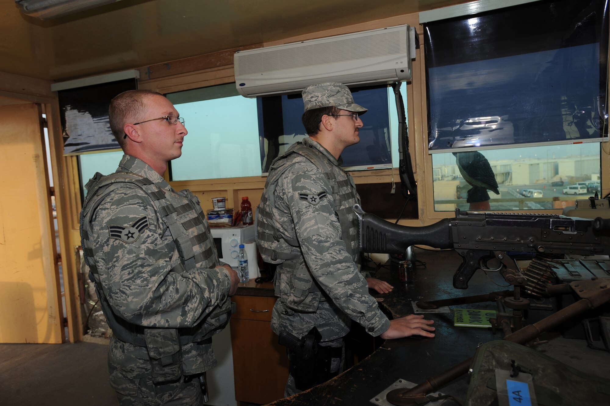Senior Airman Thomas Stone, 380th Expeditionary Security Forces Squadron, and Airman 1st Class Euel Atkinson, 380th ESFS, stand ready in a watch tower should intruders attempt entry to the base. Keeping Security Forces on 24-hour watch helps minimize the frequency of threats on base. Airman Stone is deployed from the 375th SFS, Scott AFB, Ill. Airman Atkinson is stationed out of 6th SFS, MacDill AFB, Fla. (U.S. Air Force photo by Senior Airman Maynelinne De La Cruz)
