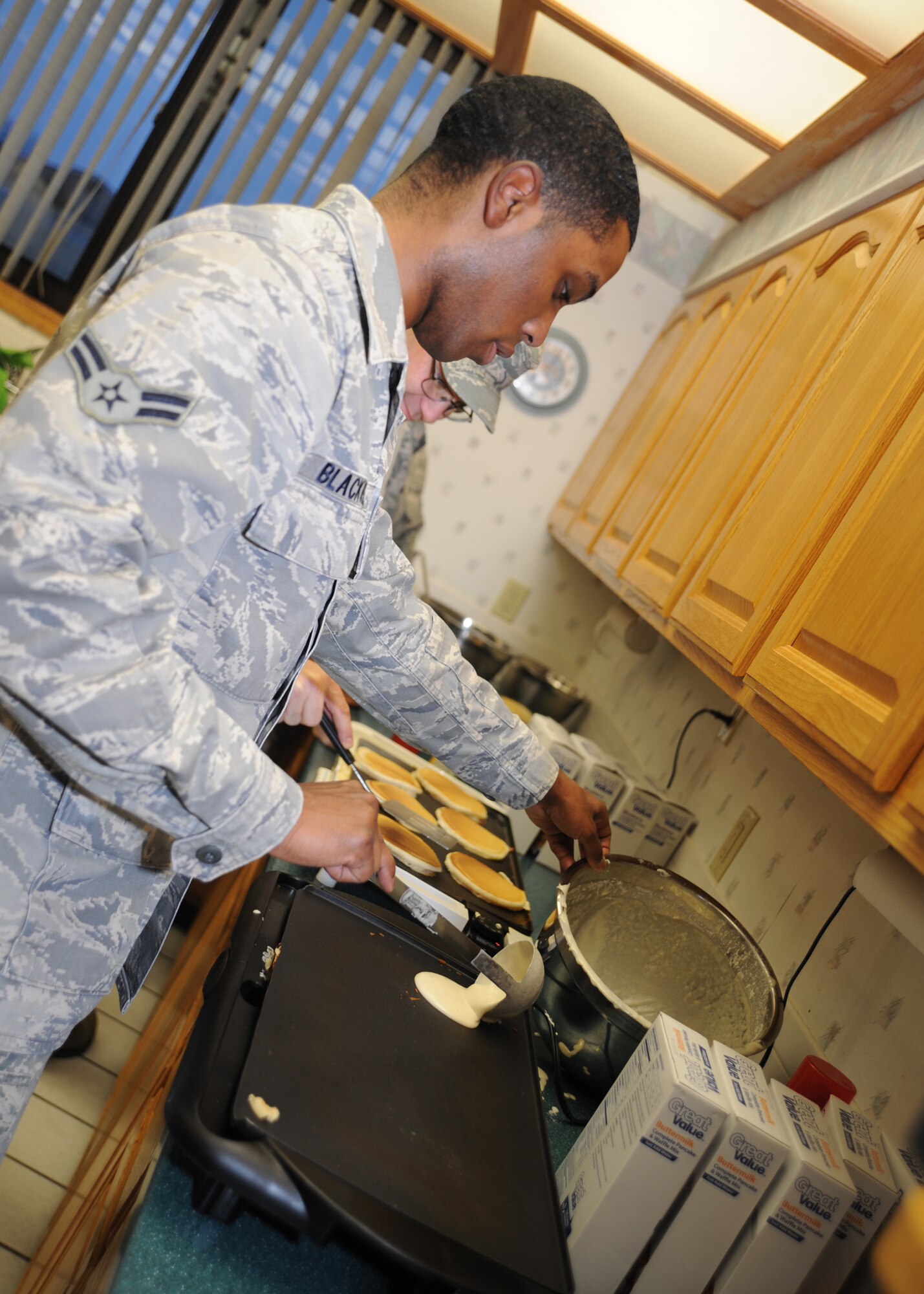 Airman 1st Class Christopher Blackwell, 22nd Communication Squadron official mail center apprentice, makes pancakes for the McConnell Air Force Assistance Fund kick-off breakfast at the base chapel March 7, 2011, McConnell Air Force Base, Kan. Volunteers from McConnell’s AFAF,  project officers and key workers assisted with the breakfast, which started the six week campaign. The AFAF financially helps the Air Force Aid Society provide worldwide emergency assistance to Airmen and their families. (U.S. Air Force photo/Senior Airman Maria A. Ruiz)