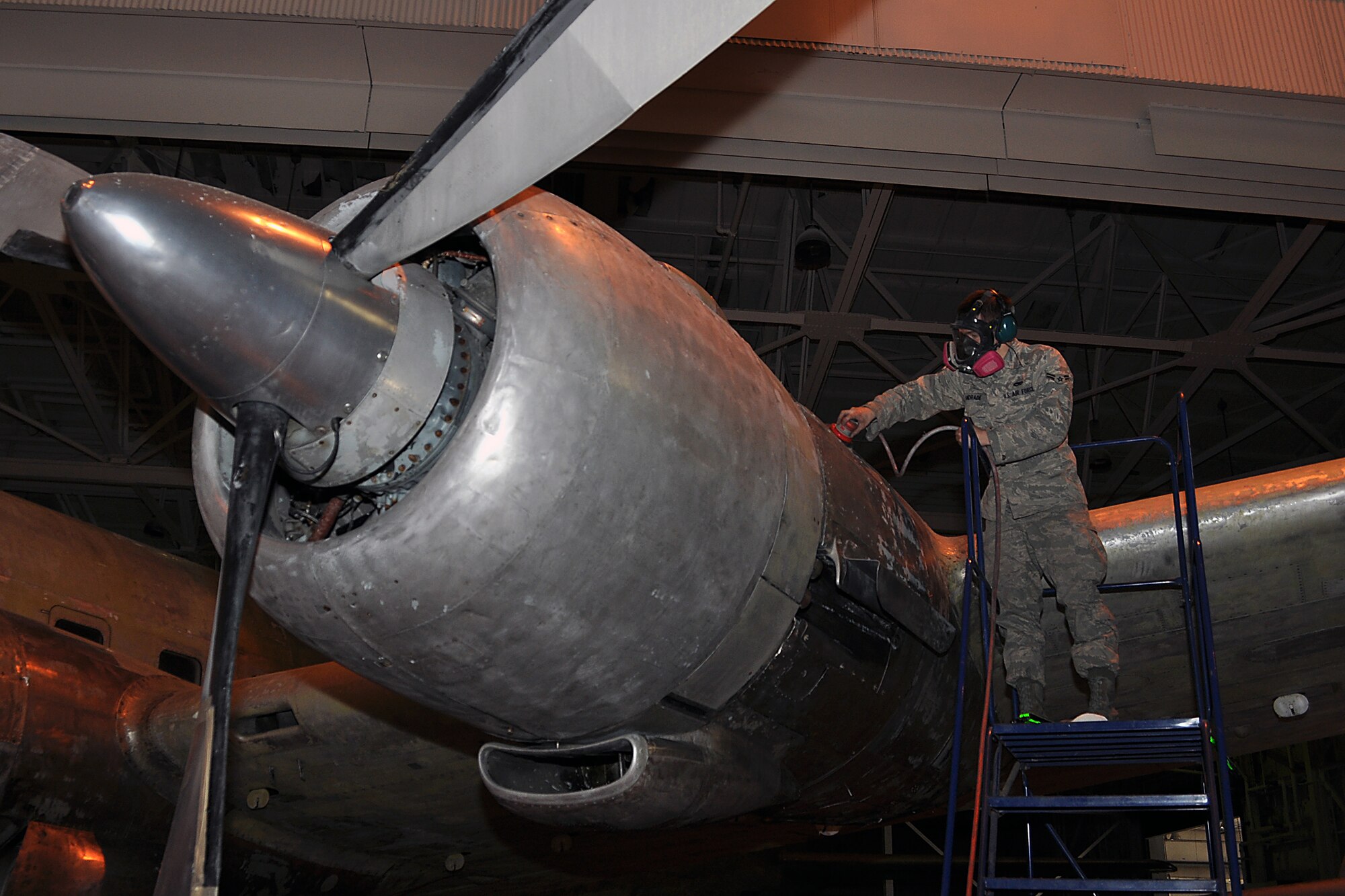 JOINT BASE MCGUIRE-DIX-LAKEHURST, N.J. -- Airman 1st Class Marco Andrade, 305th Maintenance Squadron, removes corrosion from a C-118 Liftmaster in an aircraft maintenance hangar here March 4, 2011. Liftmasters were the first cargo airplanes stationed here and helped the base to define its role as an air mobility gateway. The C-118 is being restored by active-duty Airmen, Reserve Airmen and civilians in an effort to return the aircraft to its position as a static display on the traffic circle near the passenger terminal here. (U.S. Air Force photo/Tech. Sgt. Shawn J. Jones)