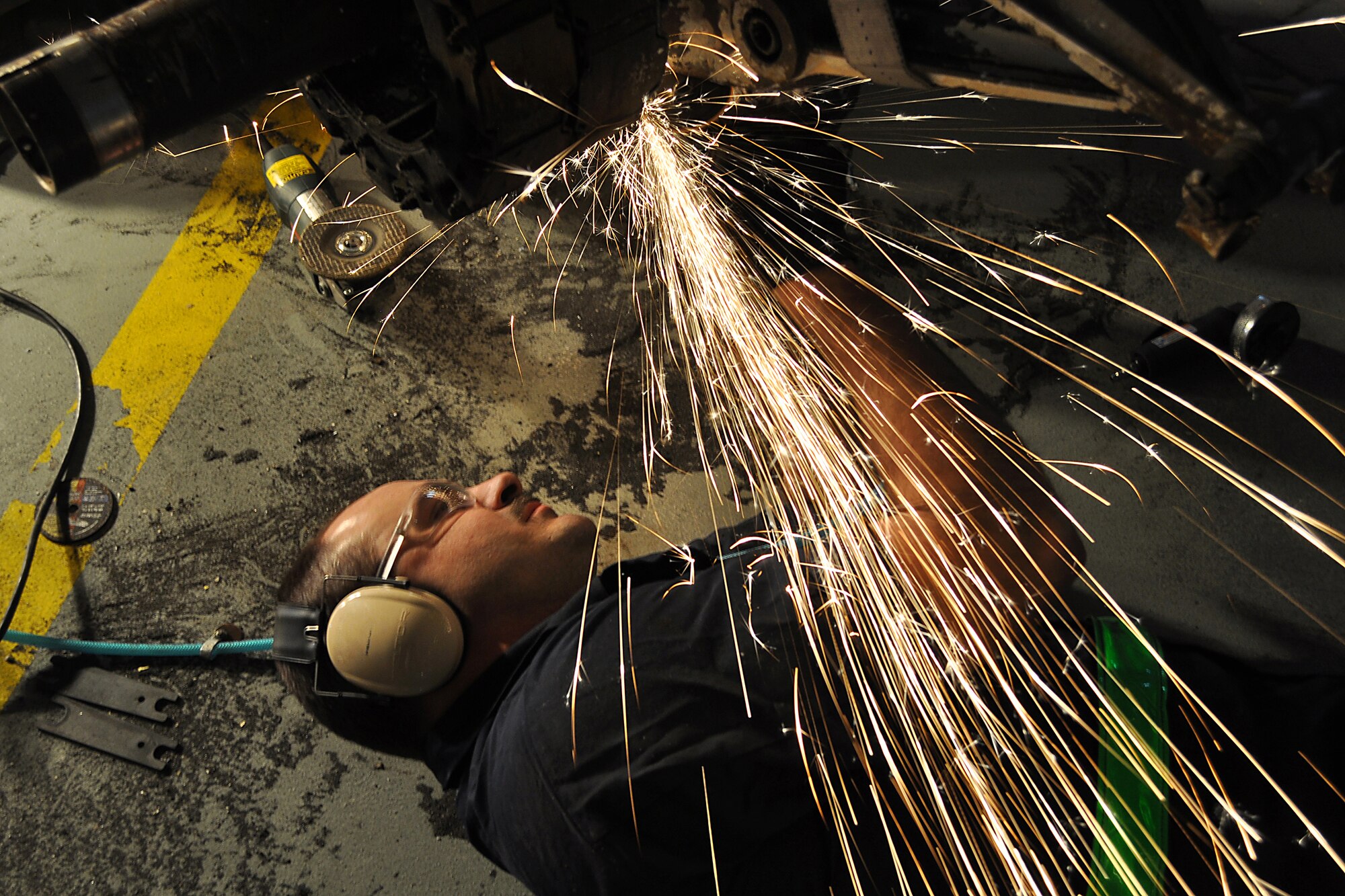JOINT BASE MCGUIRE-DIX-LAKEHURST, N.J. ? Sparks fly as Tech. Sgt. Joseph Martinek, a metals technology specialist with the 305th Maintenance Squadron, grinds down a mount that was connected to the landing gear of a C-118 Liftmaster in an aircraft maintenance hangar here March 4, 2011. Liftmasters were the first cargo airplanes stationed here and helped the base to define its role as an air mobility gateway. The C-118 is being restored by active-duty Airmen, Reserve Airmen and civilians in an effort to return the aircraft to its position as a static display on the traffic circle near the passenger terminal here. (U.S. Air Force photo/Tech. Sgt. Shawn J. Jones)