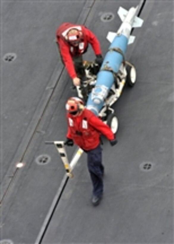 Sailors move ordnance on the flight deck of the aircraft carrier USS Enterprise (CVN 65) during flight operations while underway in the Red Sea on March 7, 2011.  The Enterprise and Carrier Air Wing 1 are on routine deployment conducting maritime security operations in the U.S. 5th Fleet area of responsibility.  