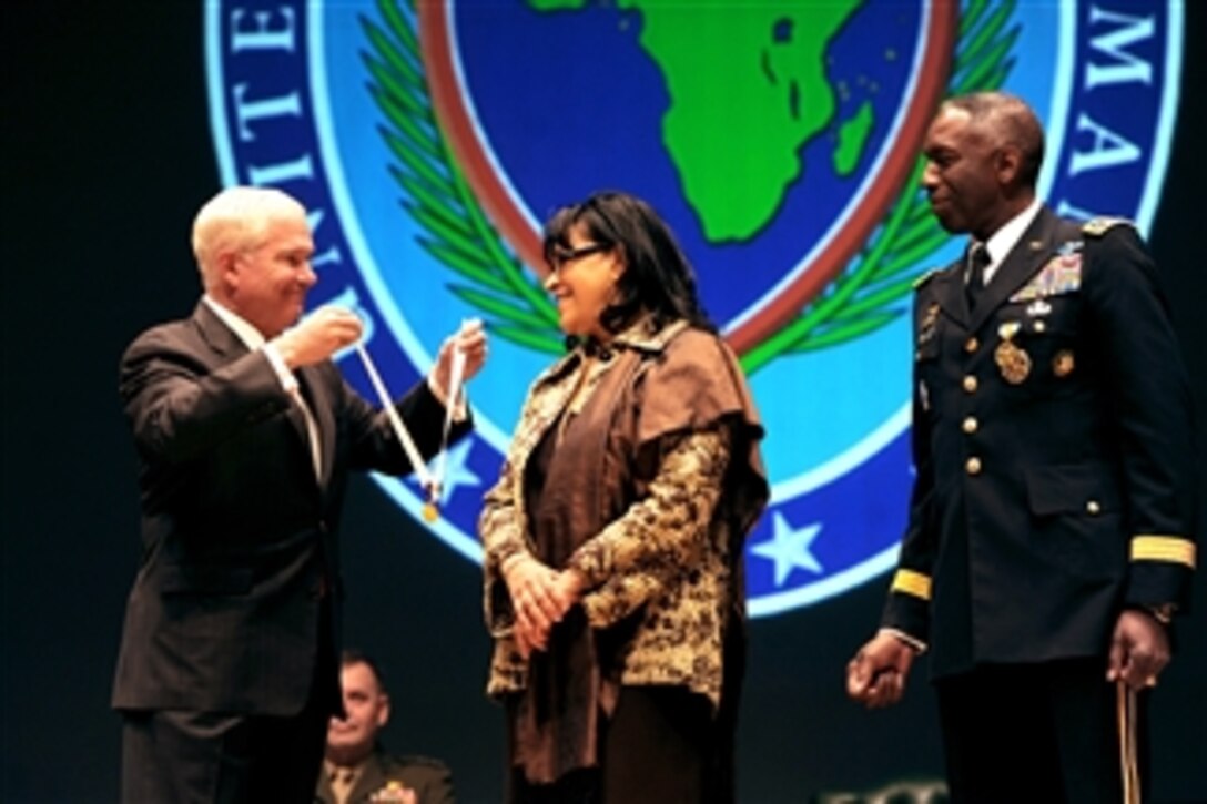 Secretary of Defense Robert M. Gates presents Joyce Ward, wife of outgoing commander of U.S. Africa Command Army Gen. William Ward, with the Distinguished Public Service Award during the AFRICOM change of command ceremony at Sindelfingen Stadthalle City Hall in Stuttgart, Germany, on March 9, 2011.  Ward, the first commander of AFRICOM, handed over the reigns to Army Gen. Carter Ham.  