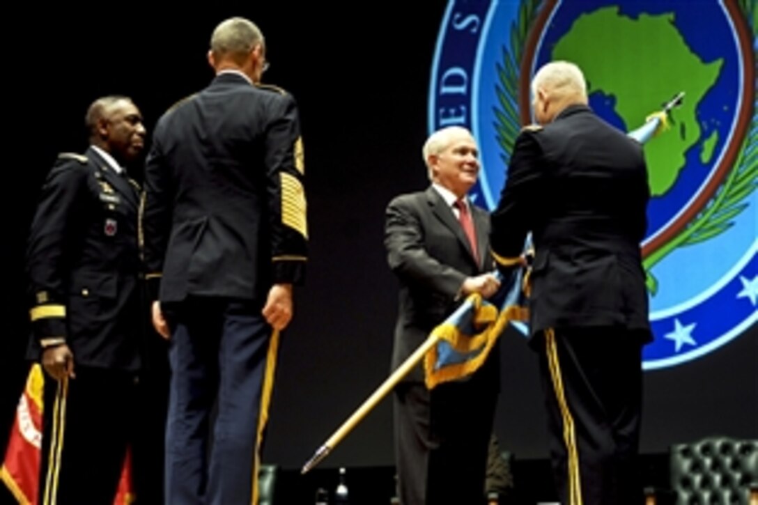 U.S. Defense Secretary Robert M. Gates passes the colors to U.S. Army Gen. Carter F. Ham, incoming commander of U.S. Africa Command, while U.S. Army Gen. William E. "Kip" Ward, outgoing commander, left, looks on during the change-of-command ceremony in Sindelfingen, Germany, March 9, 2011.