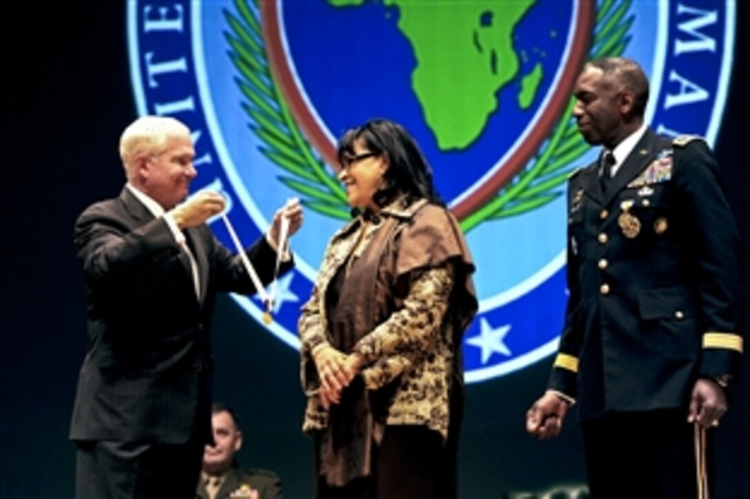 U.S. Defense Secretary Robert M. Gates presents Joyce Ward, wife of U.S. Army Gen. William E. "Kip" Ward, outgoing commander of U.S. Africa Command, with the Distinguished Public Service Award during the change-of-command ceremony in Sindelfingen, Germany, March 9, 2011. Ward handed over the reins of U.S. Africa Command to U.S. Army Gen. Carter F. Ham.