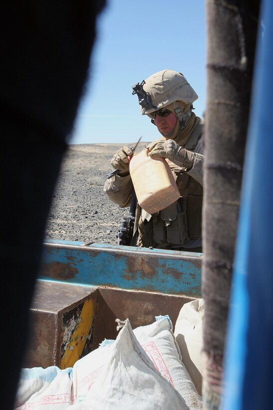 Cpl. Kevin Greenwald, a scout team leader with C Company, 3rd Light Armored Reconnaissance Battalion and a River Grove, Ill., native, searches an Afghan vehicle for signs of narcotics and other illicit materials in Helmand province, Afghanistan, March 9. Third LAR Bn. Marines have conducted thousands of vehicle checkpoints during their deployment in an effort to interdict insurgent smuggling and supply lines.