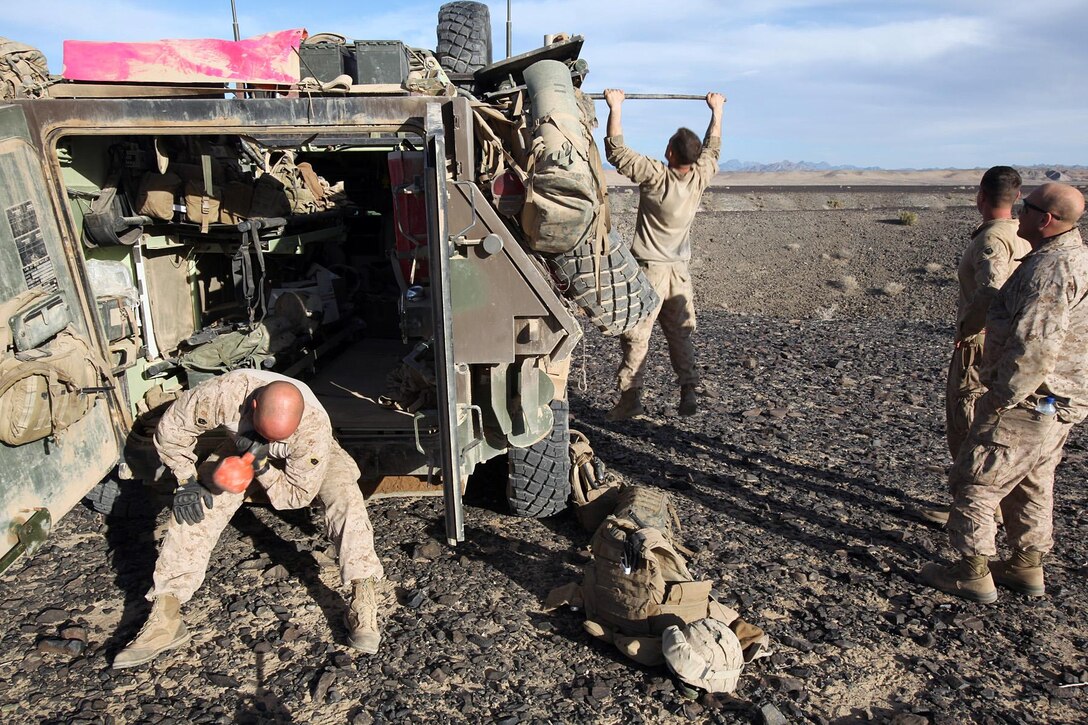1st Sgt. Justin Owens, company first sergeant and a Garland, Texas, native, and Sgt. Gabriel Schaller, company ramp chief and a Tucson, Ariz., native, get in a workout at the end of a day of interdictions in southern Helmand province, Afghanistan, March 9, while Petty Officer 3rd Class Alex Averill, senior medic and a Citrus Heights, Calif., native, and Sgt. Bradley Ivey, company communications chief and a Pinson, Ala., native, wait for their turn. The men are all with C Company, 3rd Light Armored Reconnaissance Battalion.