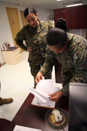 Chief Petty Officer Sylvia Suluai, head of the 2nd Marine Logistics Group Retention Team, reviews a reenlistment package before it is signed aboard Camp Lejeune, N.C., March 10, 2011. The 2nd MLG received the Retention Excellence Award for fiscal year 2010 for their outstanding efforts and commitment toward getting the best sailors to commit to another enlistment. (U.S. Marine Corps photo by Pfc. Franklin E. Mercado)