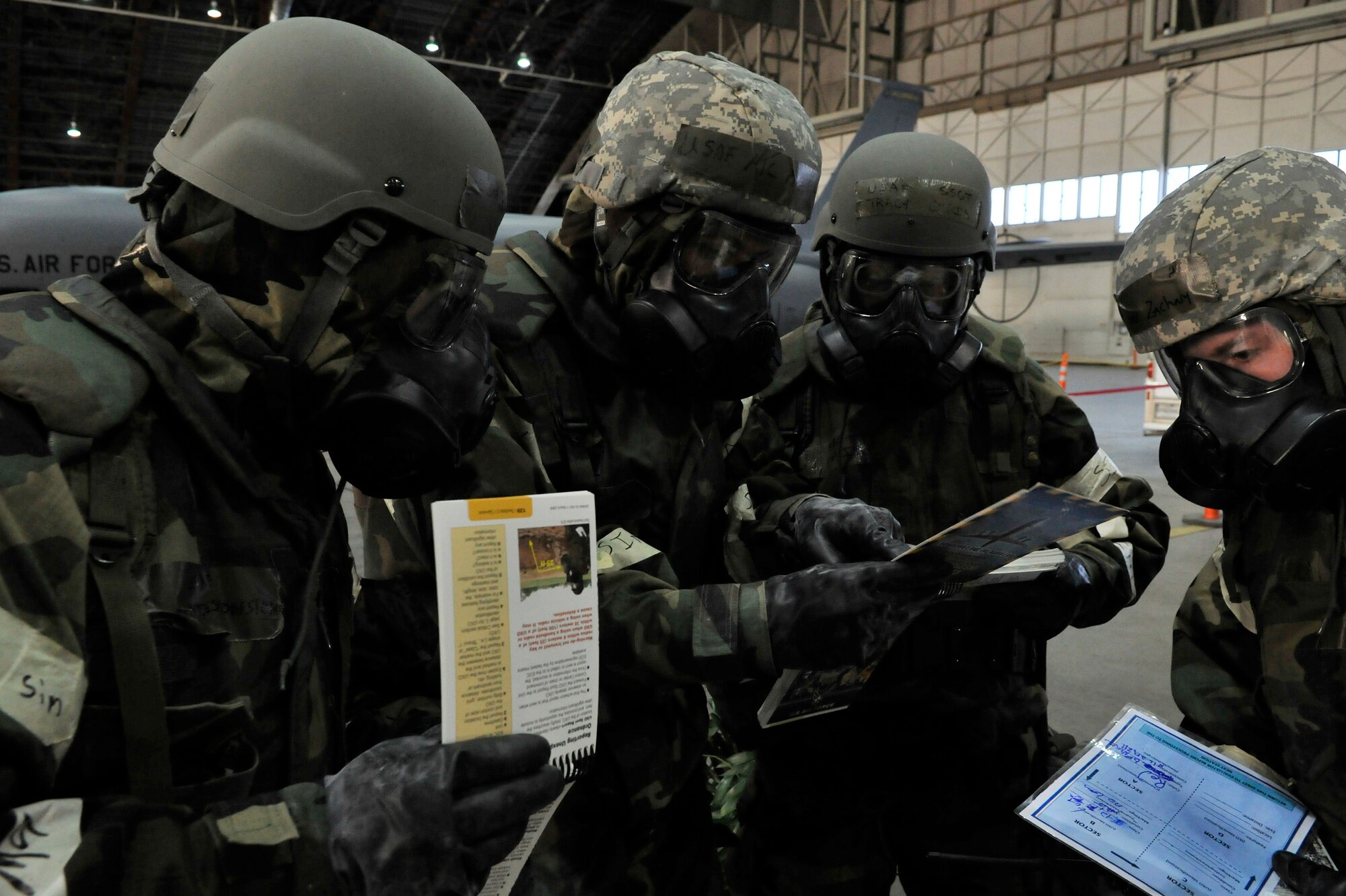 Airmen use an Airman's Manual as a reference for calling in unexploded ordnance during an operational readiness exercise evaluation March 10, 2011, Eielson Air Force Base, Alaska. The evaluation tests the ability of Airmen on how to survive and operate in a chemical, biological, radiological, nuclear and high yield explosive environment. (U.S. Air Force photo/Staff Sgt. Christopher Boitz)