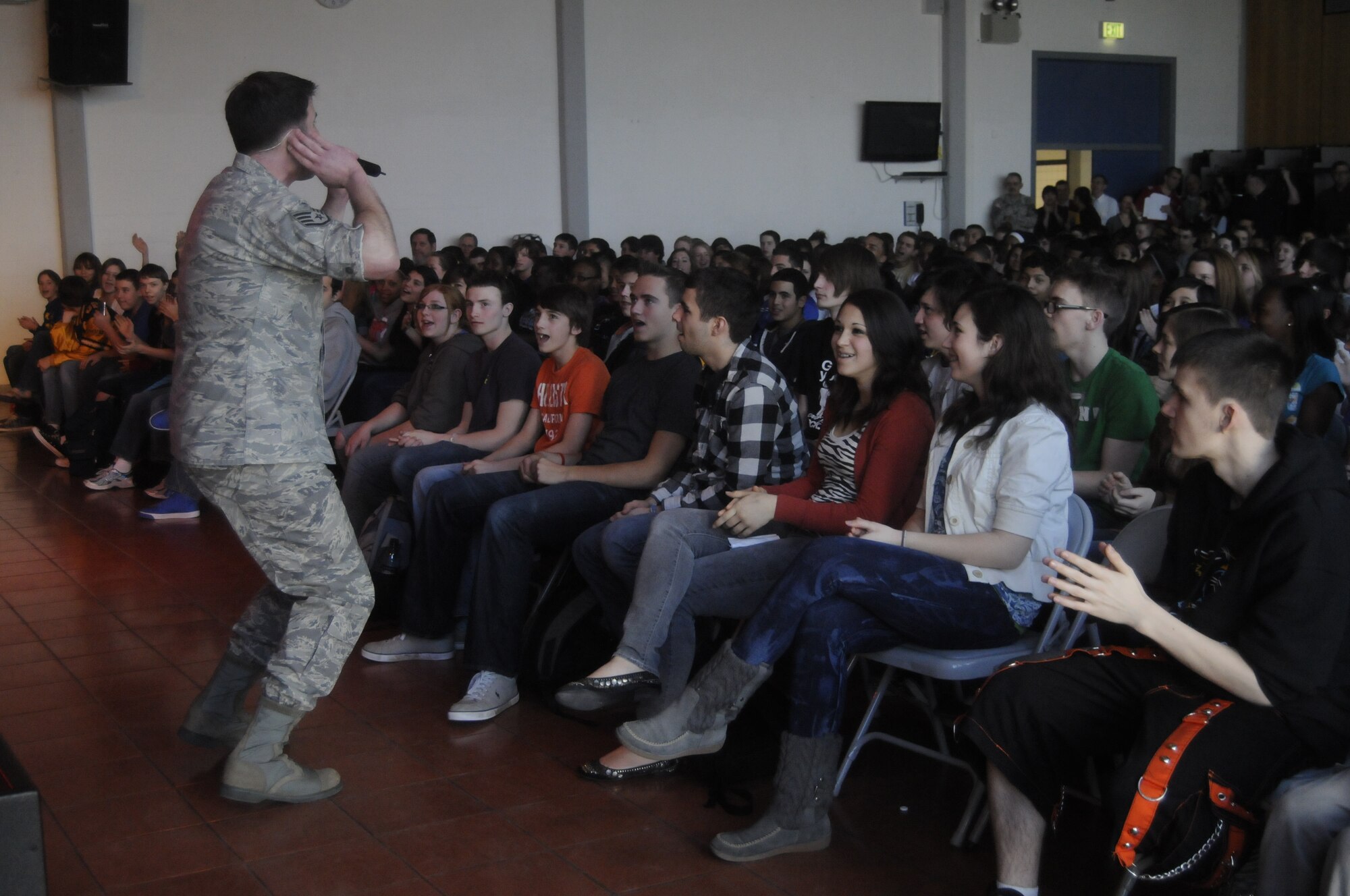 ANSBACH, Germany -- Staff Sgt. Craig Bowman, U.S. Air Forces in Europe Band Touch ‘n Go vocalist, sings to Ansbach Middle and High School students on U.S. Army Garrison Ansbach, Germany, during a performance March 9. Touch ‘n Go performed before a packed gymnasium of students and teachers at the school as part of a Music in Our Schools tour throughout Bavaria. (U.S. Air Force photo/Staff Sgt. Kali L. Gradishar)