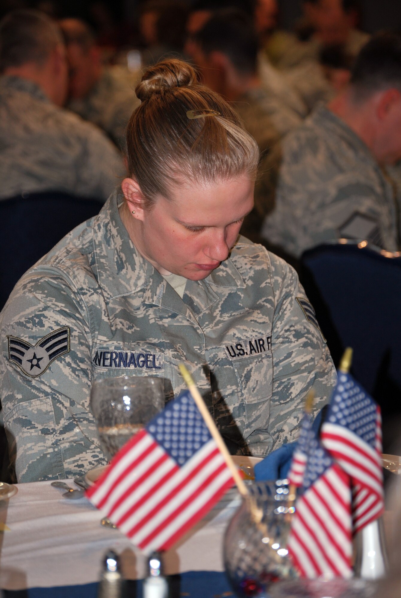 Senior Airman Courtney Kievernagel, 90th Communication Squadron, bows her head in a moment of silence during Warren’s National Prayer Luncheon in the Fall Hall Community Center March 3. (U.S. Air Force photo by Tech. Sgt. William Spencer)
