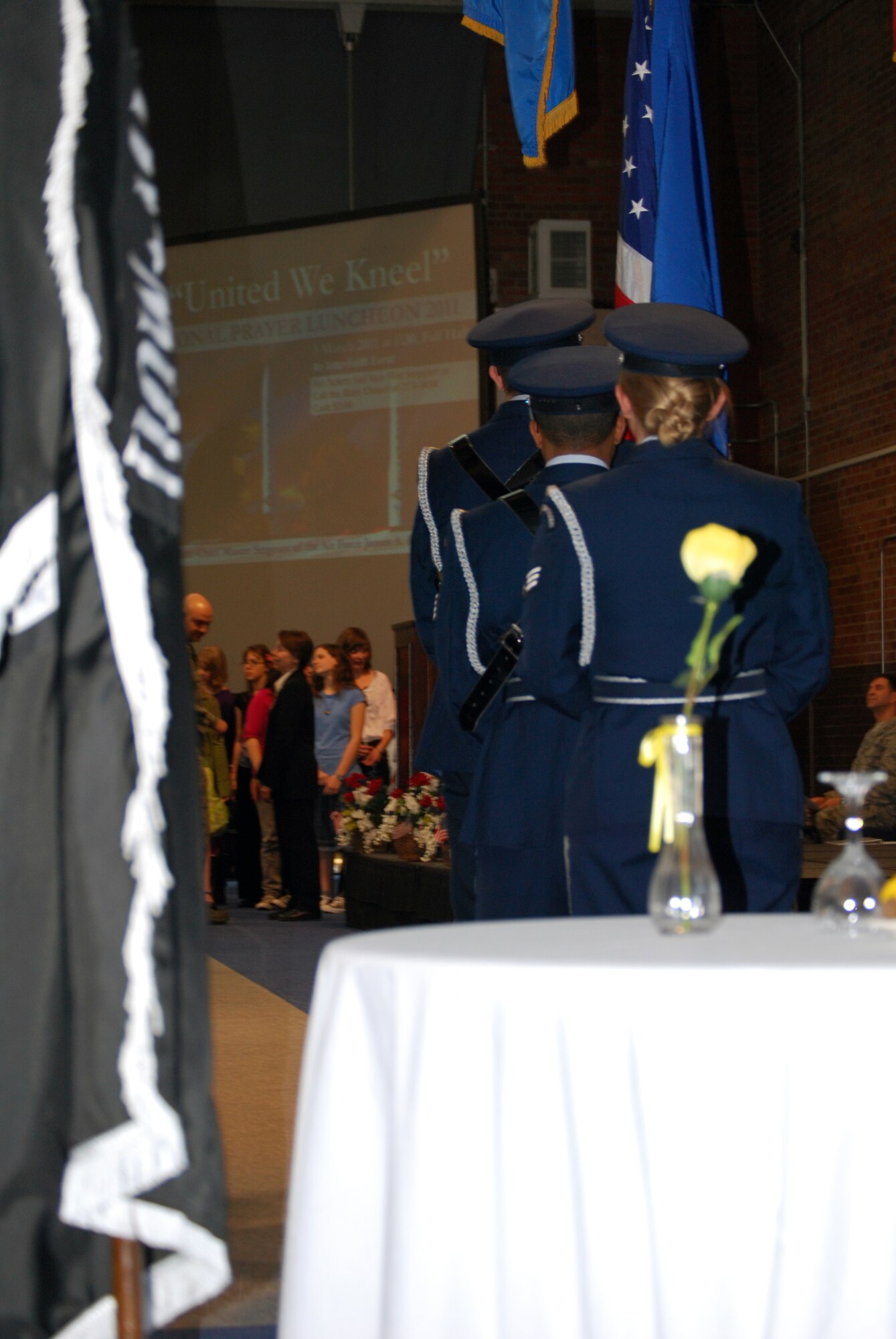 Members of Warren’s Honor Guard stand ready to present the colors as members of the Freedom Elementary Singers prepare to sing the National Anthem during Warren’s National Prayer Luncheon at the Fall Hall Community Center March 3. (U.S. Air Force photo by Tech. Sgt. William Spencer)