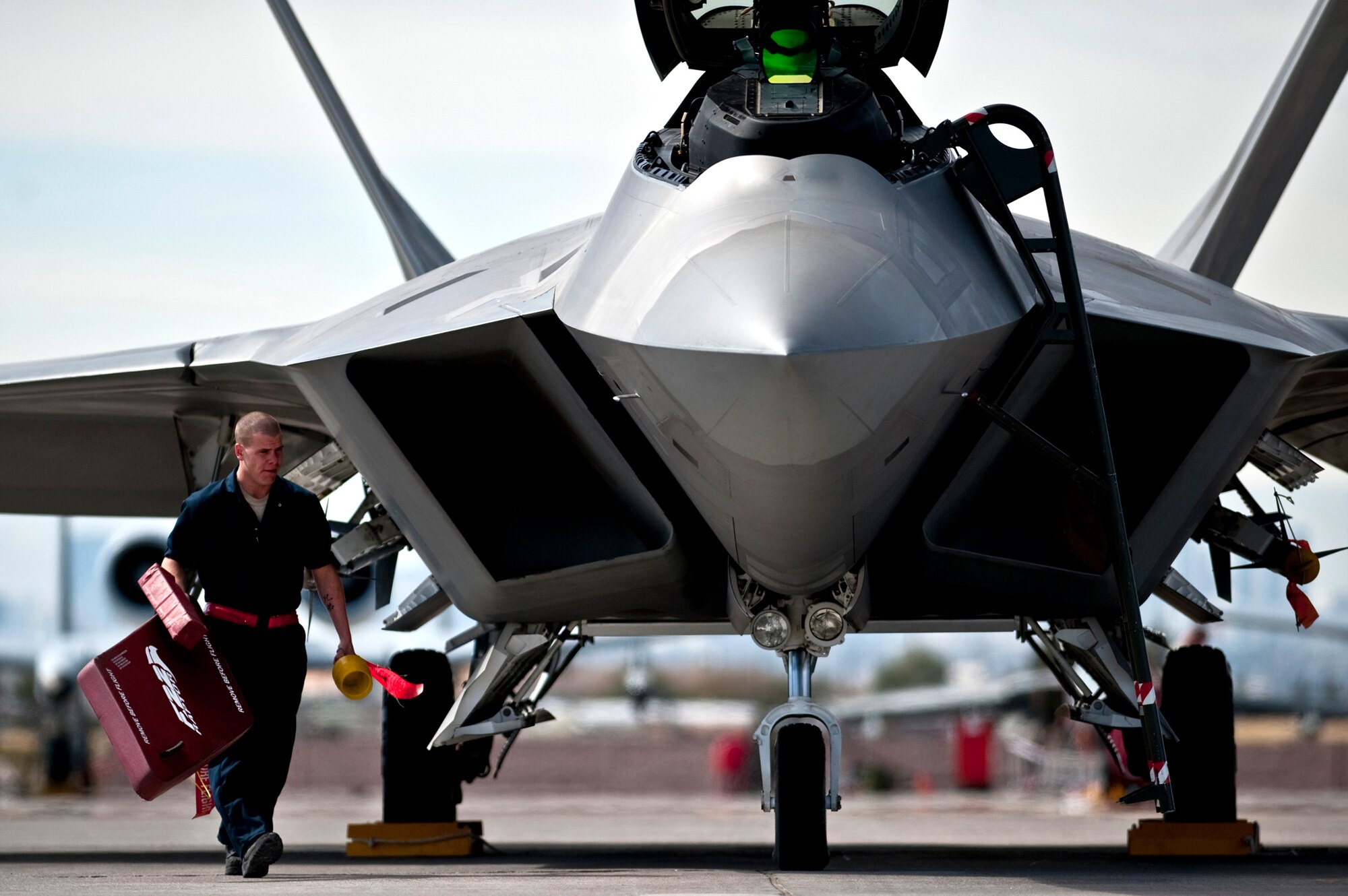 Airman 1st Class Jonathan Foster removes the intake covers from an F-22 Raptor March 2, 2011, before a Red Flag training mission at Nellis Air Force Base, Nev. Airman Foster is a crew chief assigned to the 49th Aircraft Maintenance Squadron at Holloman AFB, N.M. (U.S. Air Force photo/Tech Sgt. Michael R. Holzworth)
