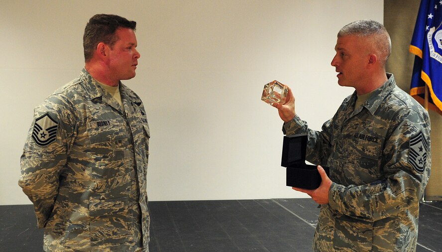 Chief Master Sgt. Robert Brooks, 9th Air Force command chief, presents a token of appreciation to  Master Sgt. Robert Disney, 347th Rescue Group superintendent from Moody Air Force Base, Ga., March 10. This token has only been awarded four other times. (U.S. Air Force photo/Senior Airman Stephanie Mancha)(RELEASED)
