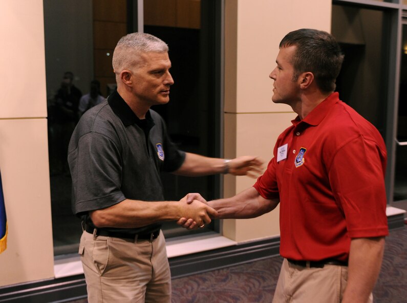 Chief Master Sgt.  Robert Brooks, 9th Air Force command chief Shaw Air Force Base, S.C., shakes hands with Tech. Sgt. Jeremy Phillips, 93rd Air Ground Operations Wing NCO annual award winner, during the medallion ceremony for the Outstanding Performers of the Year held at the James H. Rainwater Conference Center in Valdosta, Ga., March 9. Each nominee was greeted by the 9th AF commander and command chief during the ceremony. (U.S. Air Force photo Airman 1st Class Benjamin Wiseman)(RELEASED)