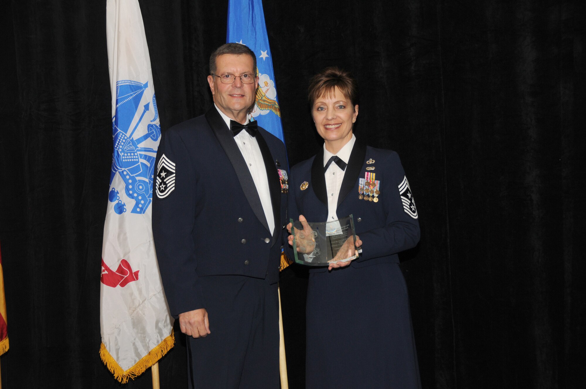 Chief Master Sgt. Dan Irving, Arizona State Command Chief, presents guest speaker Chief Master Sgt. Denise Jelinski-Hall a plaque of appreciation during the Airmen of the Year Banquet at the Chaparral Suites and Resorts in Scottsdale Ariz, Saturday, March 5, 2011. Chief Jelinski-Hall is the Senior Enlisted Leader for the National Guard Bureau. (U.S. Air Force photo by Airman 1st Class Rashaunda Williams/Released)