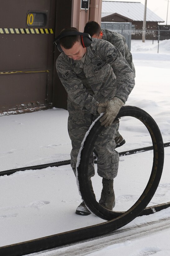 (Front) Airmen 1st Class Phil Laugle and Jonathan Hendricks, 28th Logistics Readiness Squadron fuels technicians, inspect fuel hoses at Ellsworth Air Force Base, S.D., March 7, 2011. Airmen Laugle and Hendricks examined the hoses for leaks and damage. (U.S. Air Force photo/Senior Airman Kasey Close)