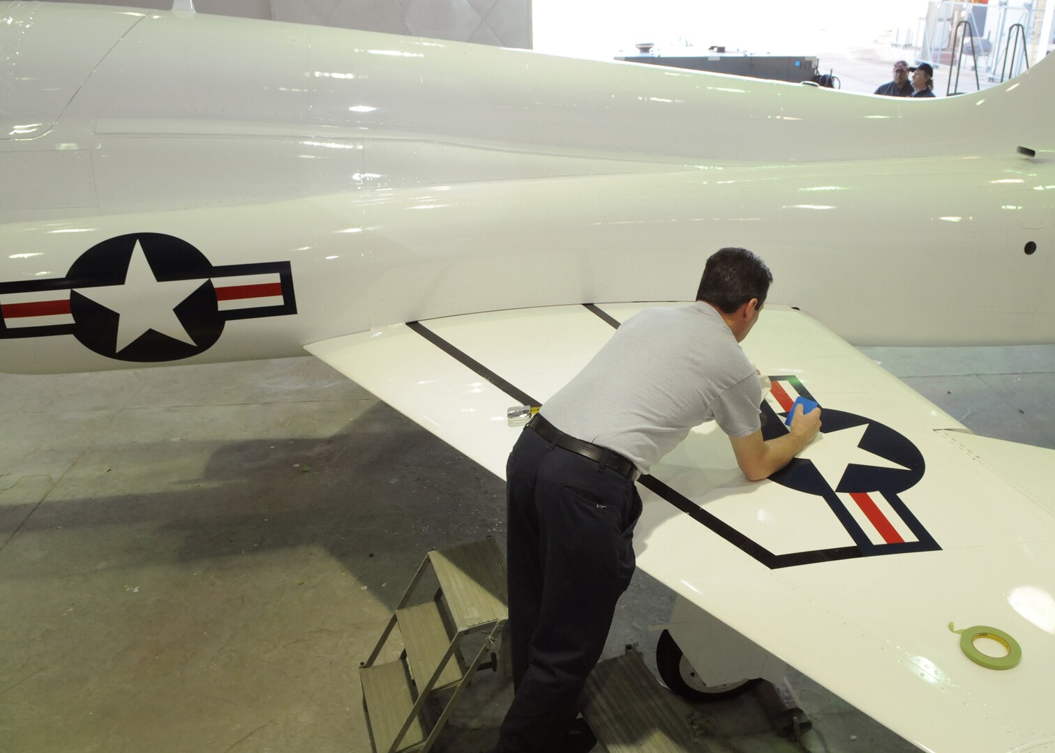 Neil Orlowski, 12th Flying Training Wing corrosion control, applies new decals to a T-38 Talon March 10. To mark the 50th anniversary of service, the aircraft was repainted to match the colors used on the aircraft during the 1960s. The T-38 celebrates 50 years of service March 17. (U.S. Air Force photo/David Terry)