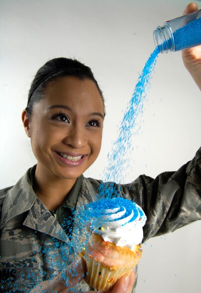 Airman 1st Class Pauline Lyons sprinkles a cupcake on March 8, 2011 at Fairchild Air Force Base, Wash. She is a patient administrator with beneficiary services for the 92nd Medical Support Squadron and a baker. She bakes goods for her shop and when she bakes cupcakes, she also decorates them. Most recently she made a bouquet of cupcakes by decorating a plate with green frosting for stems and making each cupcake a flower. (U.S. Air Force Photo/Senior Airman Natasha E. Stannard) 