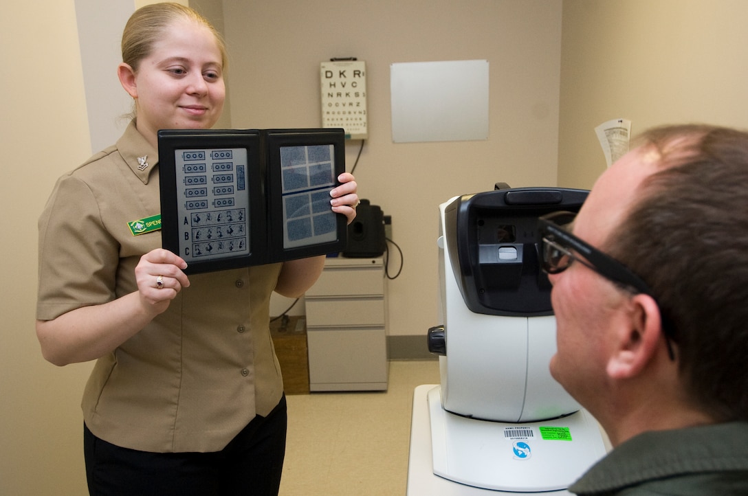 Navy Hospital Corpsman 2nd Class Meggan Spence gives a depth perception test to Cmdr. Roger Johnson, a Naval flight officer assigned to Patrol Squadron 69, Naval Air Station Whidbey Island, Oak Harbor, Washington. (U.S. Air Force photo/Bobby Jones)