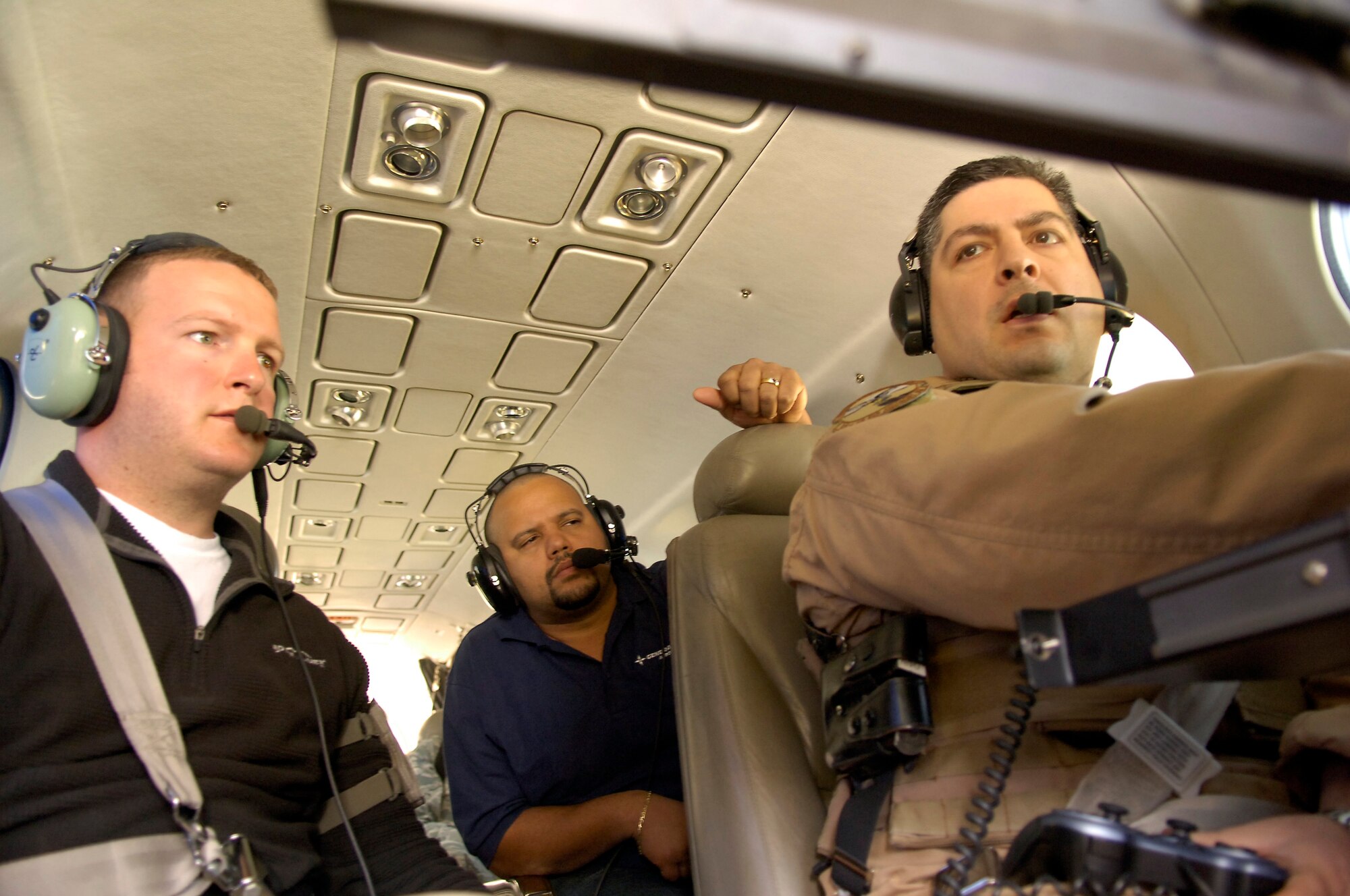 BAGHDAD -- Tech. Sgt. Troy DeLeon, 321st Air Expeditionary Advisory Group missions system operator, right, discusses data recorded during a flight March 3 with Jacob Flanagan, left, and Carlos Baez, civilian contractors with General Atomics. Sergeant DeLeon is deployed with the Iraq Training and Advisory Mission-Air to teach Iraqi airmen how to operate critical missions systems on the King Air 350. Sergeant DeLeon, a Pensacola, Fla., native, is deployed from Robins Air Force Base, Ga. (U.S. Air Force photo by Tech. Sgt. Randy Redman)