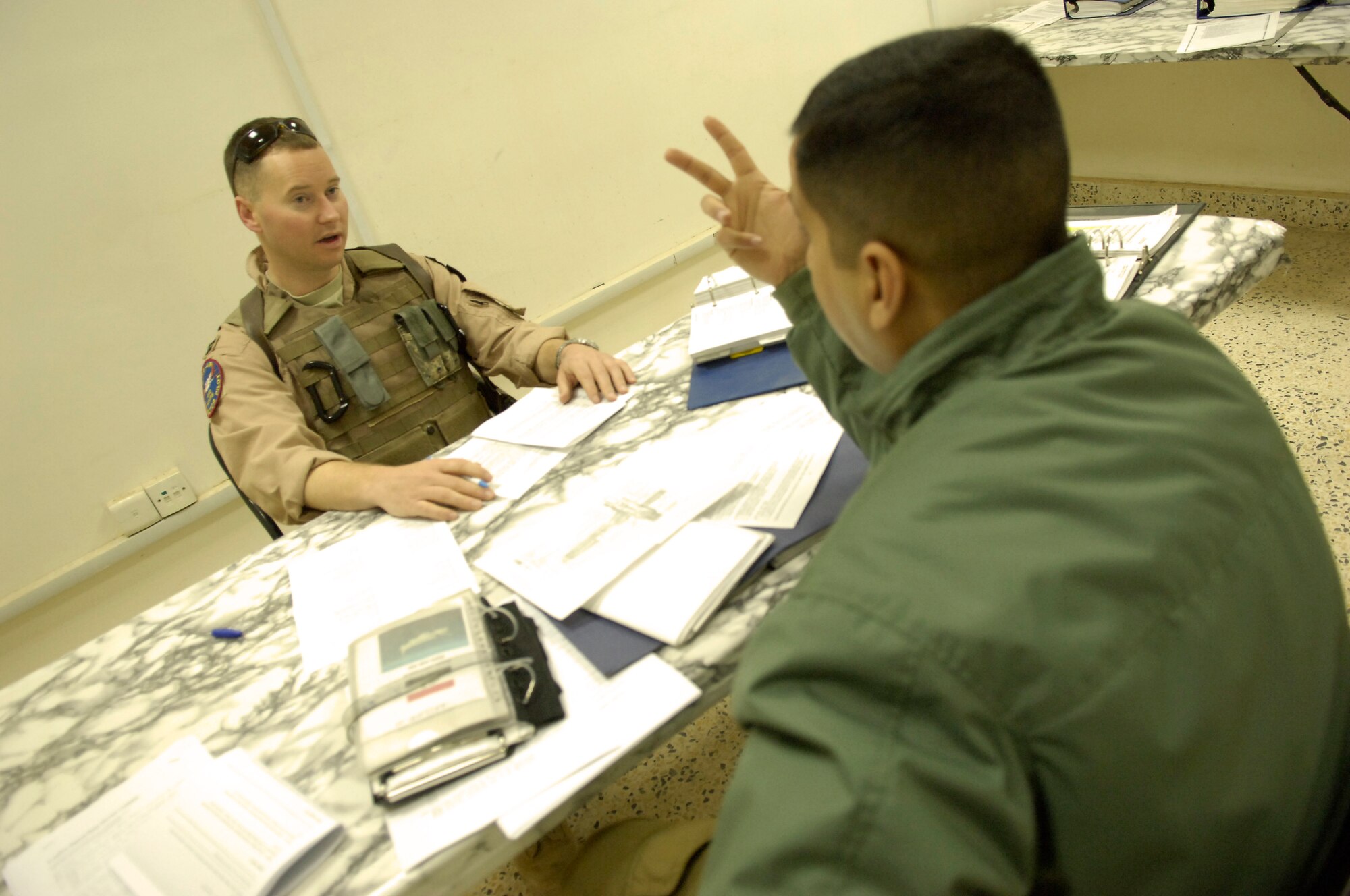 BAGHDAD -- U.S. Navy Lt. Philip Ritchie, King Air Military Training Team training officer, goes through a pre-flight briefing with an Iraqi pilot from Squadron 87 at New Al-Muthana Air Base March 3. Lieutenant Ritchie is deployed with the Iraq Training and Advisory Mission-Air to train Iraqi pilots how to fly the King Air 350. Lieutenant Ritchie, an Austin, Texas, native, is deployed from Naval Air Station Corpus Christi, Texas. (U.S. Air Force photo by Tech. Sgt. Randy Redman)